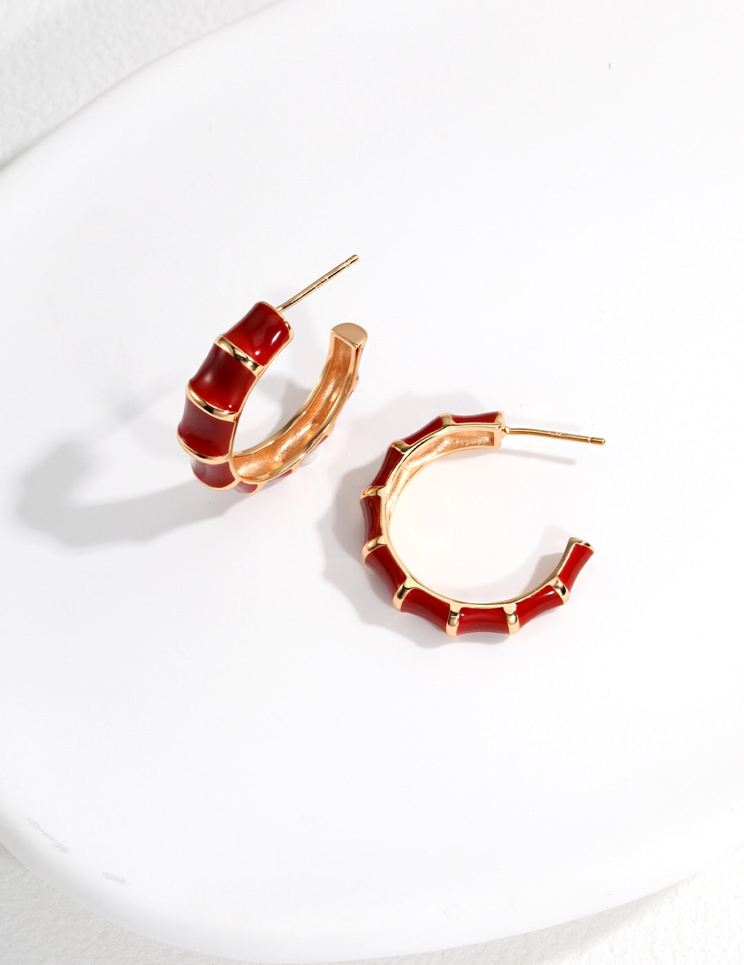 A pair of handmade red enamel glaze bamboo earrings with gold vermeil detailing, showcasing their vibrant color and elegant design.