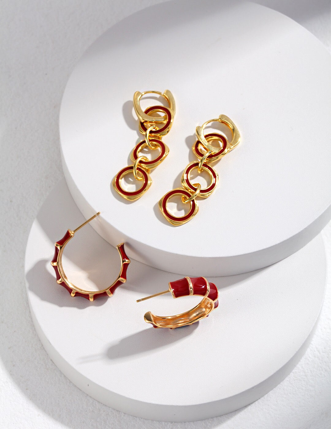 A pair of handmade red enamel glaze bamboo earrings with gold vermeil detailing, showcasing their vibrant color and elegant design.