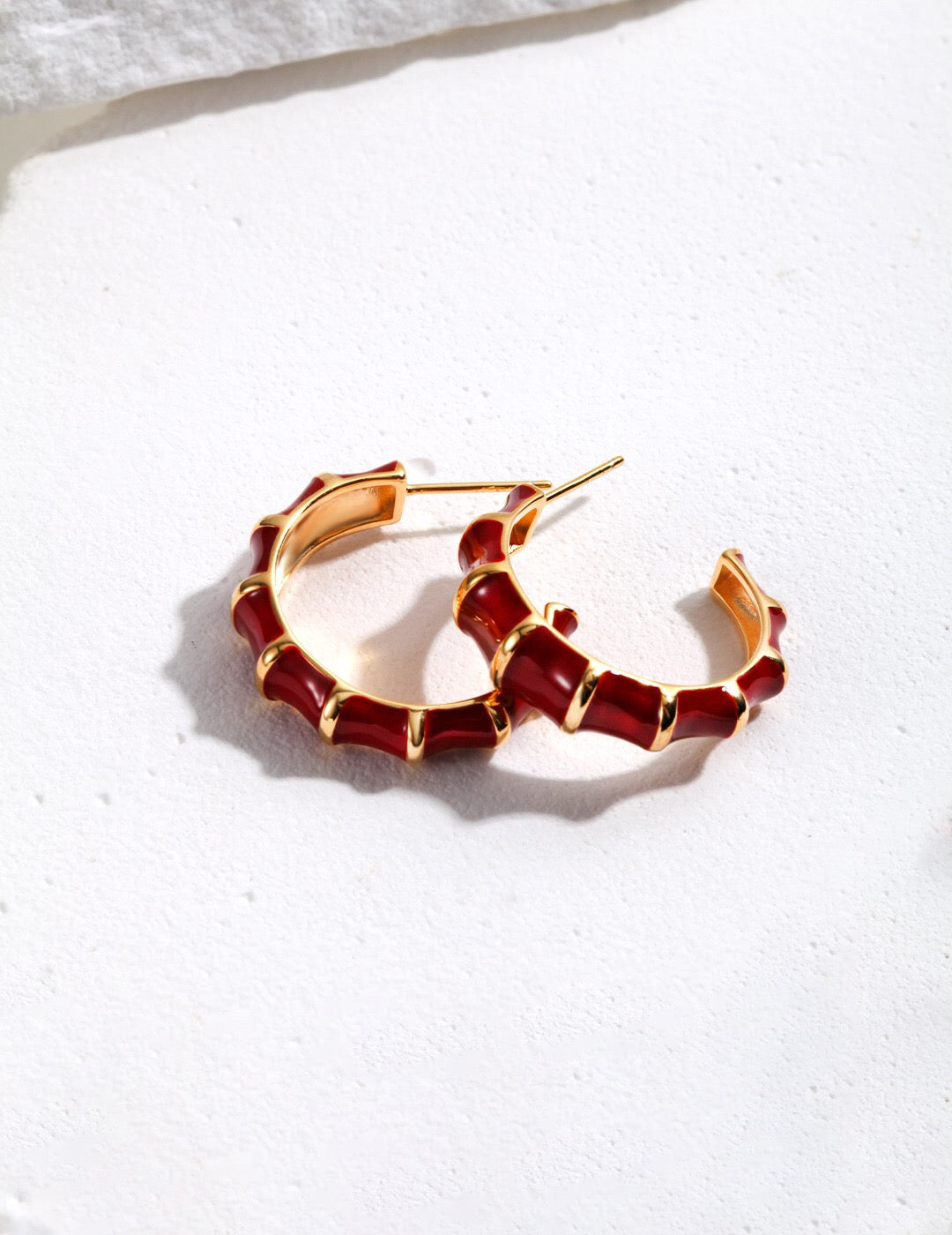 A pair of handmade red enamel glaze bamboo earrings with gold vermeil detailing, showcasing their vibrant color and elegant design.