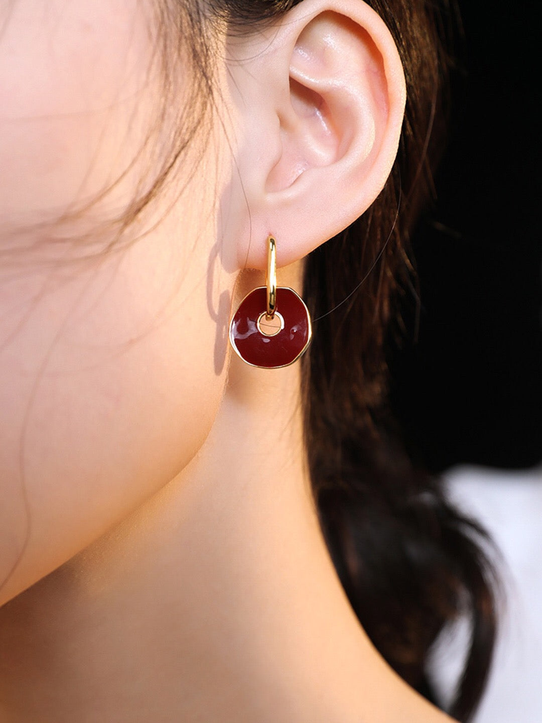 A pair of handmade red enamel earrings with gold vermeil plating, showcasing a unique design and elegant craftsmanship.