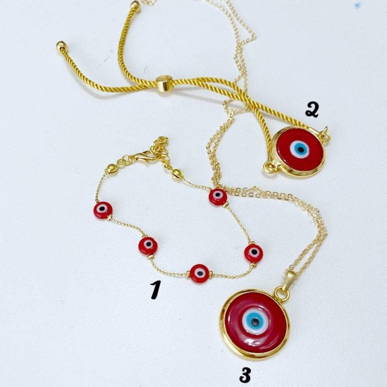 A beautiful collection of Red Evil Eye Jewelry including a bracelet and necklace made with red Murano glass and gold accents, symbolizing protection and good luck.