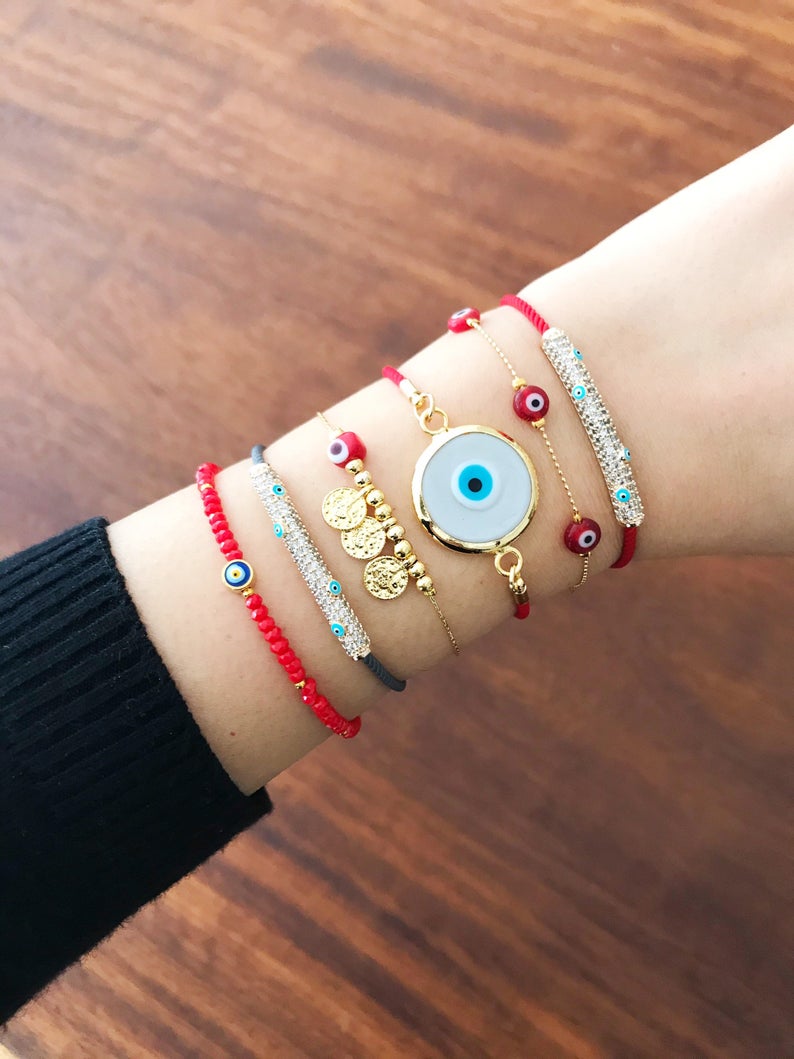 A beautiful collection of Red Evil Eye Jewelry including a bracelet and necklace made with red Murano glass and gold accents, symbolizing protection and good luck.