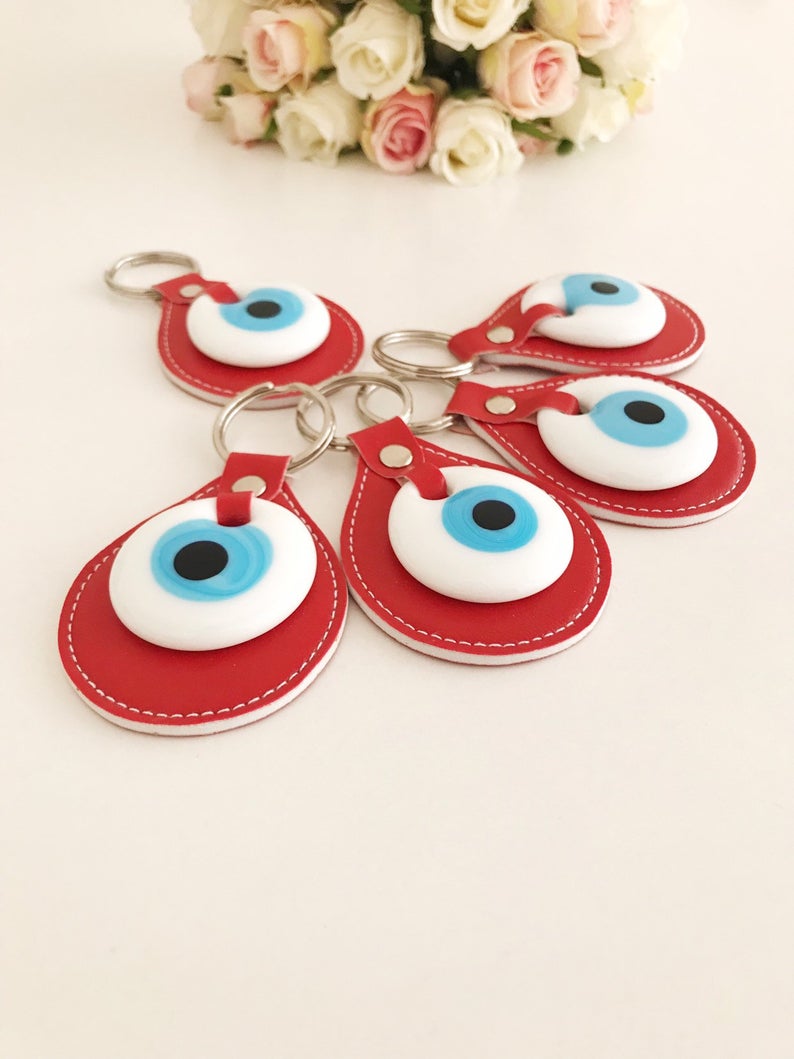 A vibrant red leather keychain featuring a glass evil eye, symbolizing protection and good luck, perfect for keys or bags.