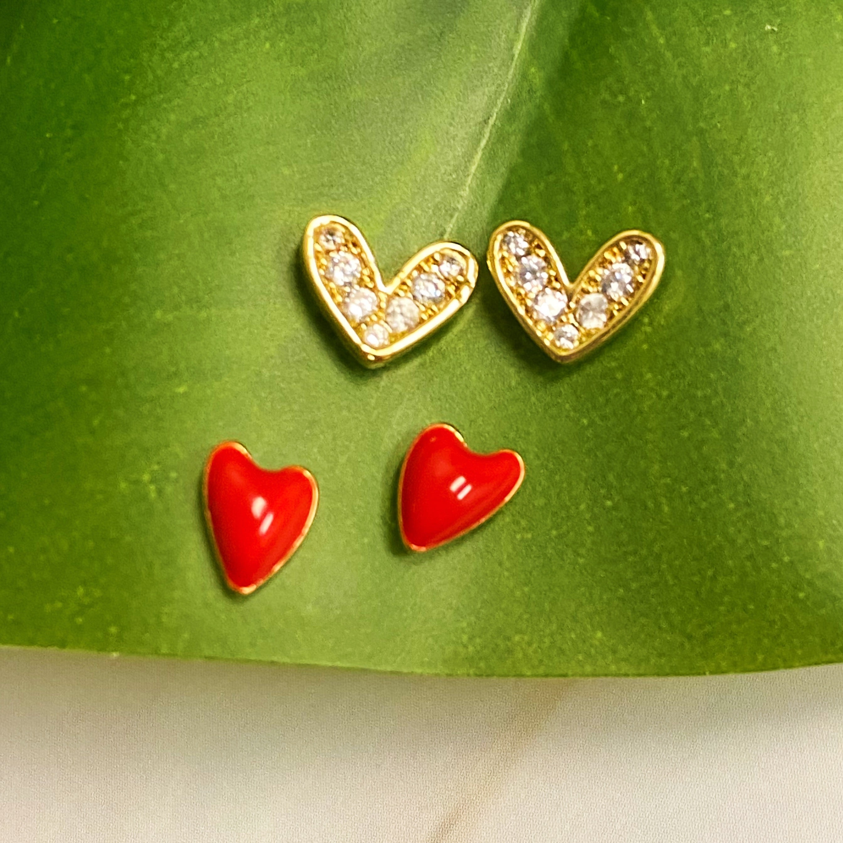 A set of two red heart earrings, one simple and one sparkling, crafted from 18k gold plated brass.