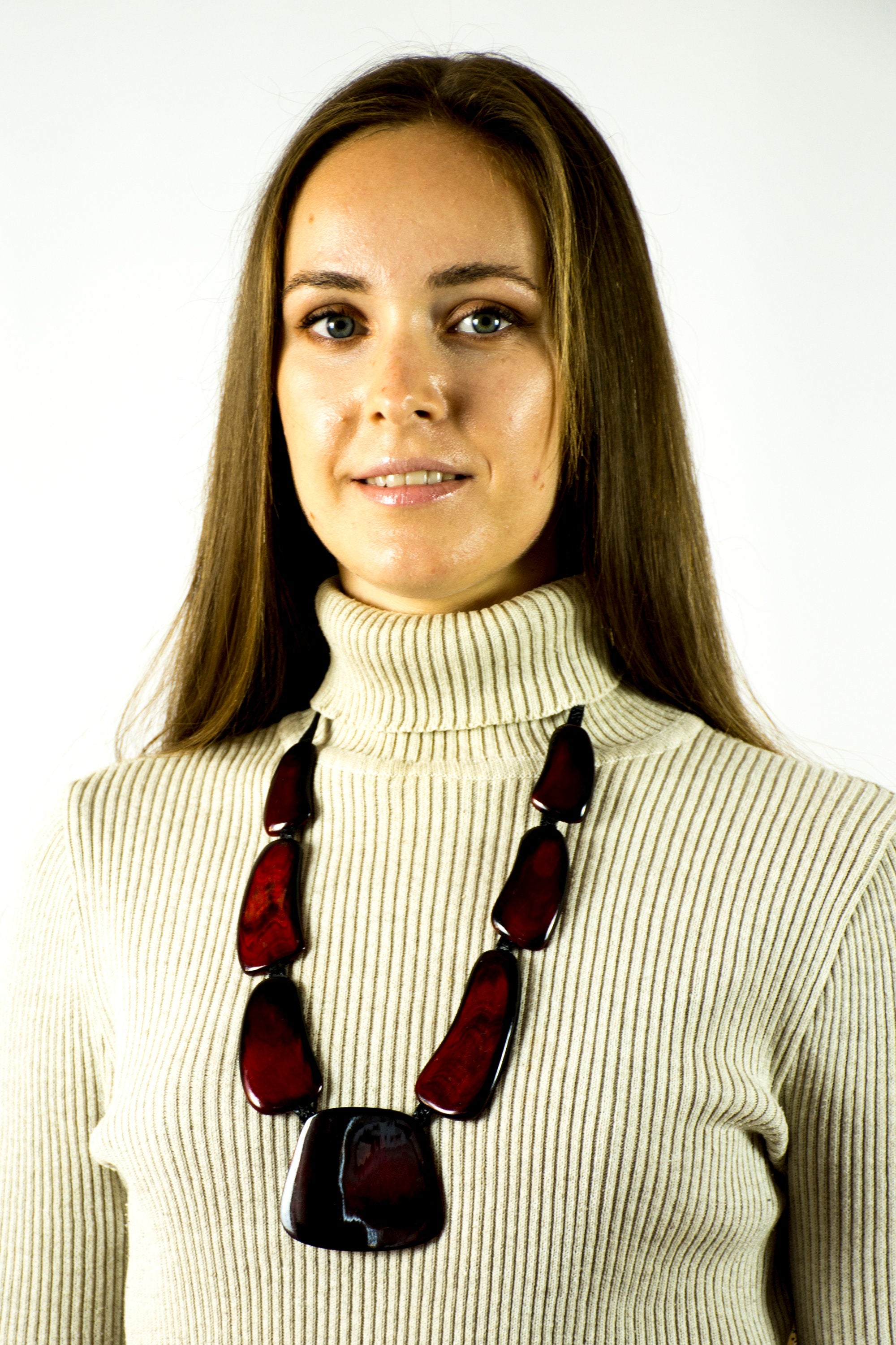 A handmade red necklace for women, crafted from cow horn and connected with a black leather cord, showcasing a unique and stylish design.