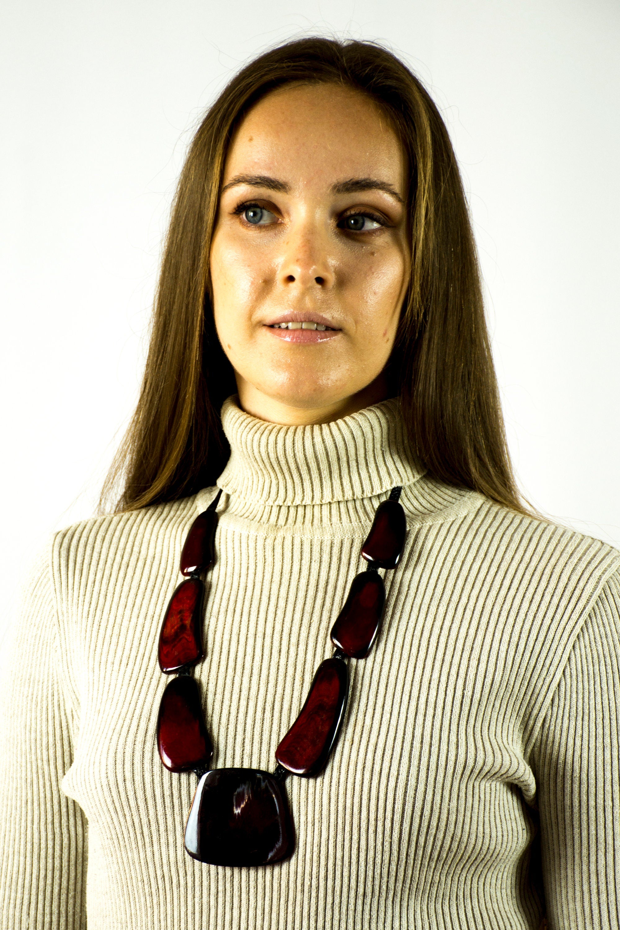 A handmade red necklace for women, crafted from cow horn and connected with a black leather cord, showcasing a unique and stylish design.