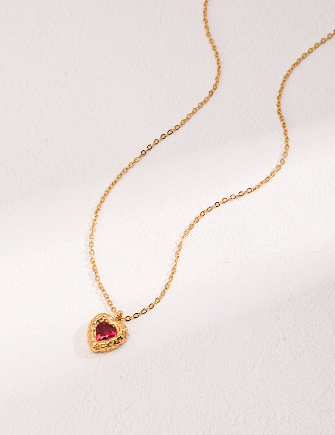 A beautiful Red Steel Jade Love Zircon Necklace featuring a heart pendant, crafted from 18ct gold vermeil and zircon stones.