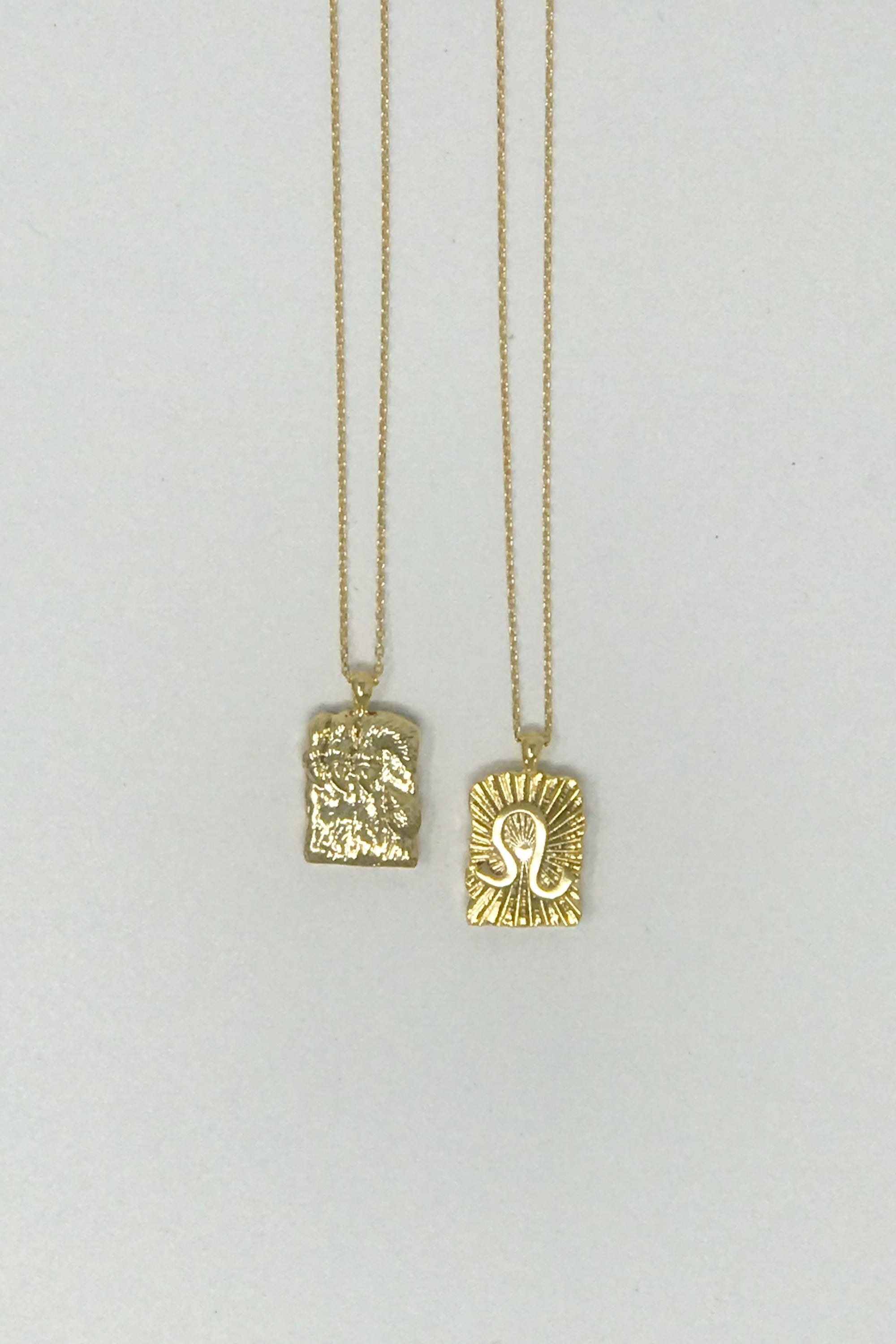 Elegant reversible gold pendant necklace featuring zodiac constellation signs, showcasing both sides of the design.