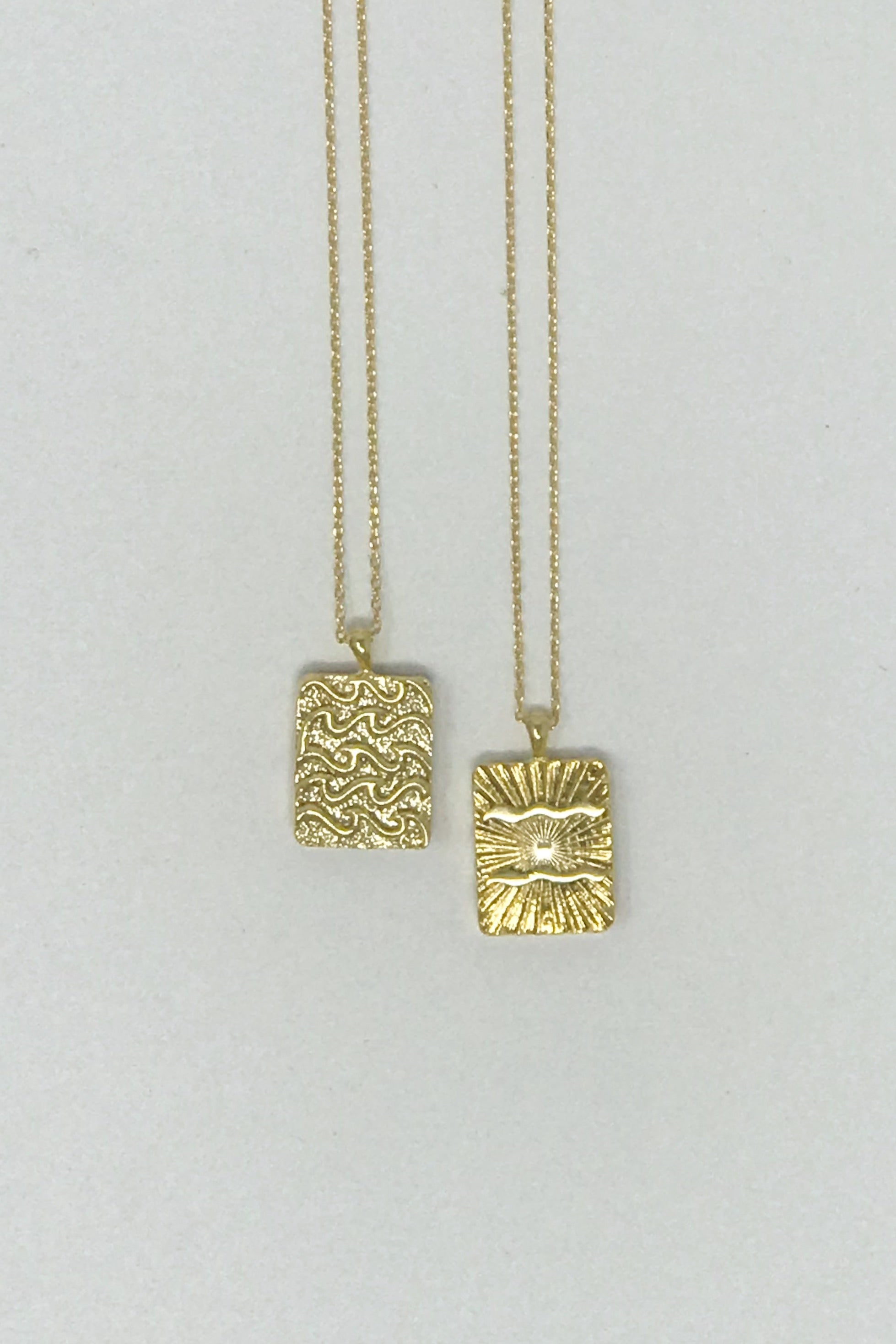 Elegant reversible gold pendant necklace featuring zodiac constellation signs, showcasing both sides of the design.