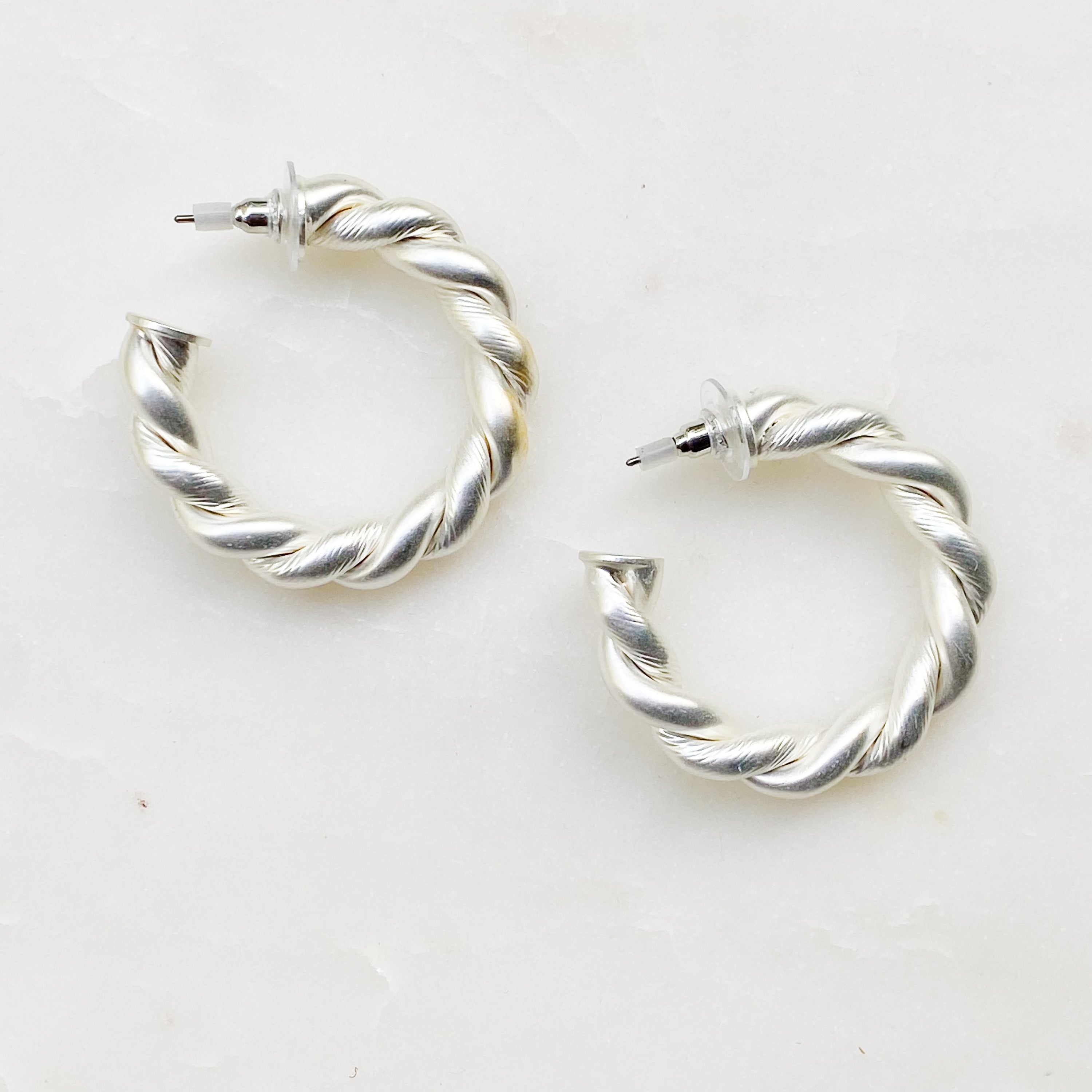 Riley Braided Hoop Earrings featuring a stylish twisted design with a matt finish, measuring approximately 1.5 inches in diameter.