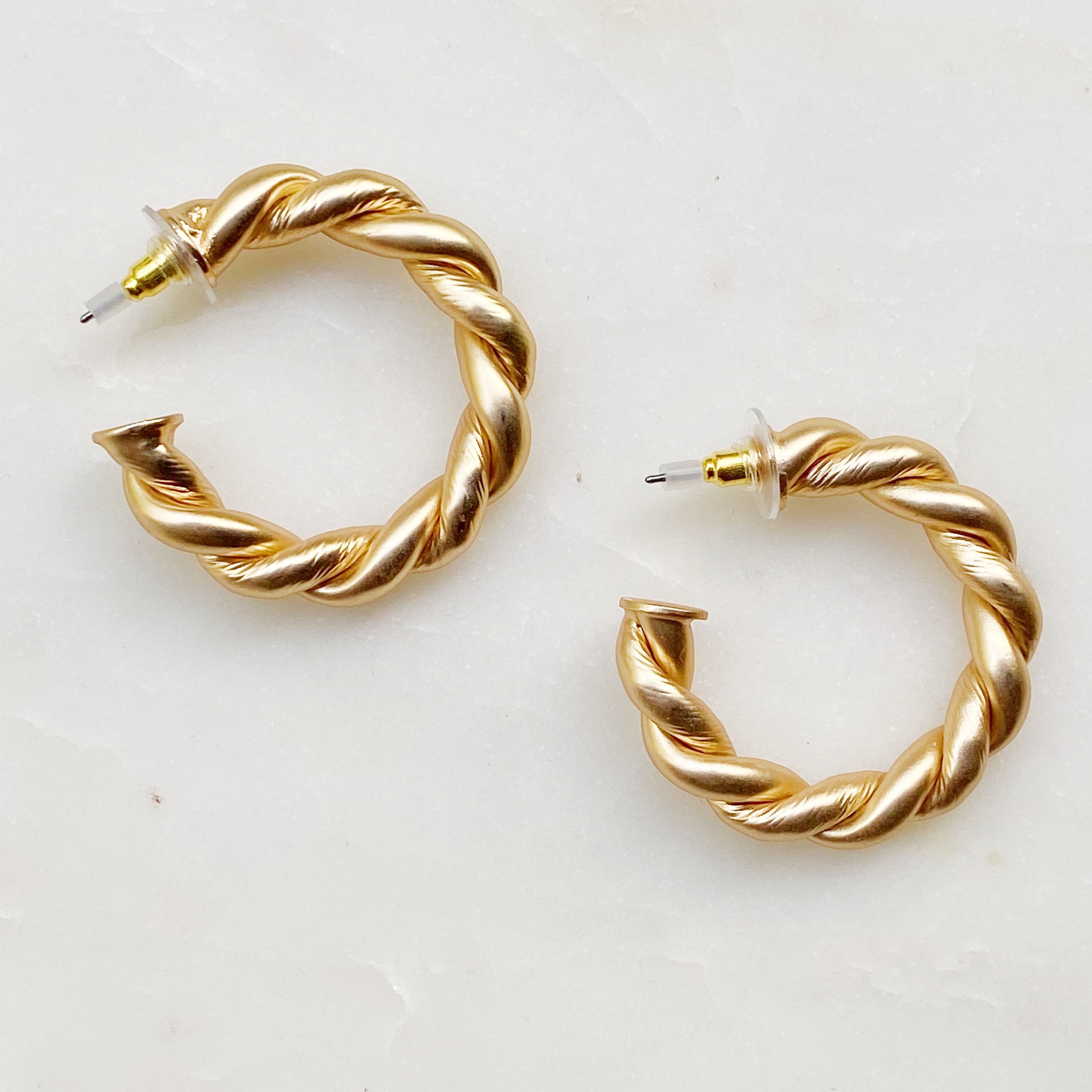 Riley Braided Hoop Earrings featuring a stylish twisted design with a matt finish, measuring approximately 1.5 inches in diameter.