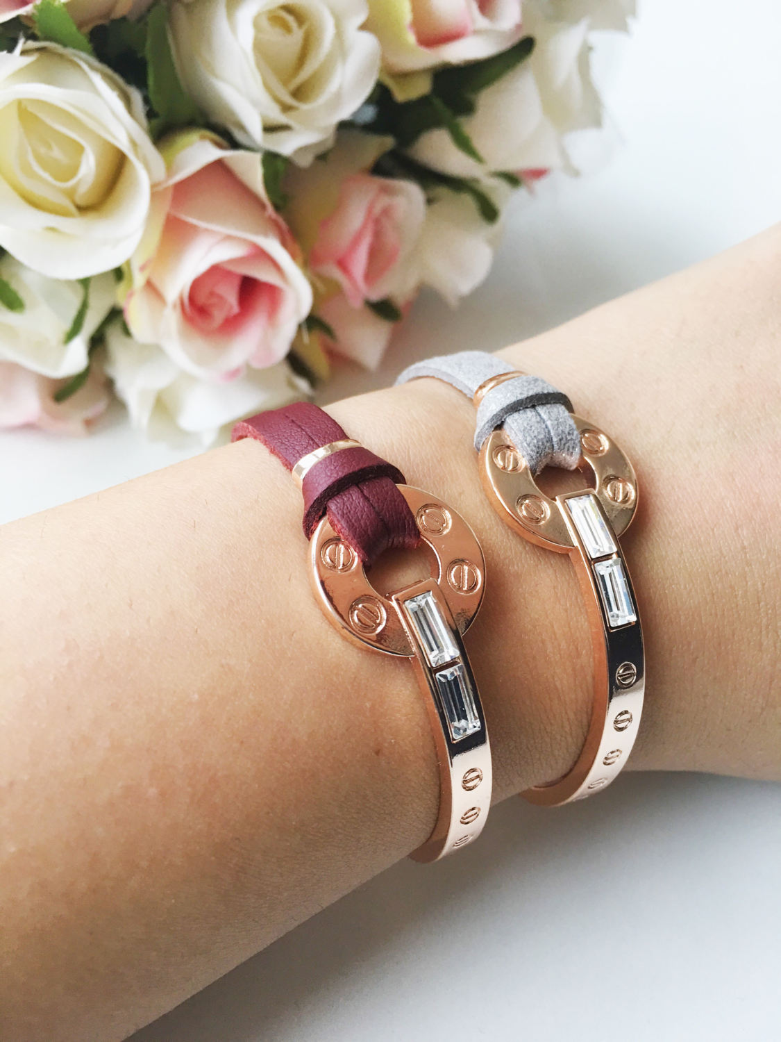 A stylish rose gold leather bracelet featuring a cubic zirconia charm, available in red and gray colors, showcasing its adjustable design.