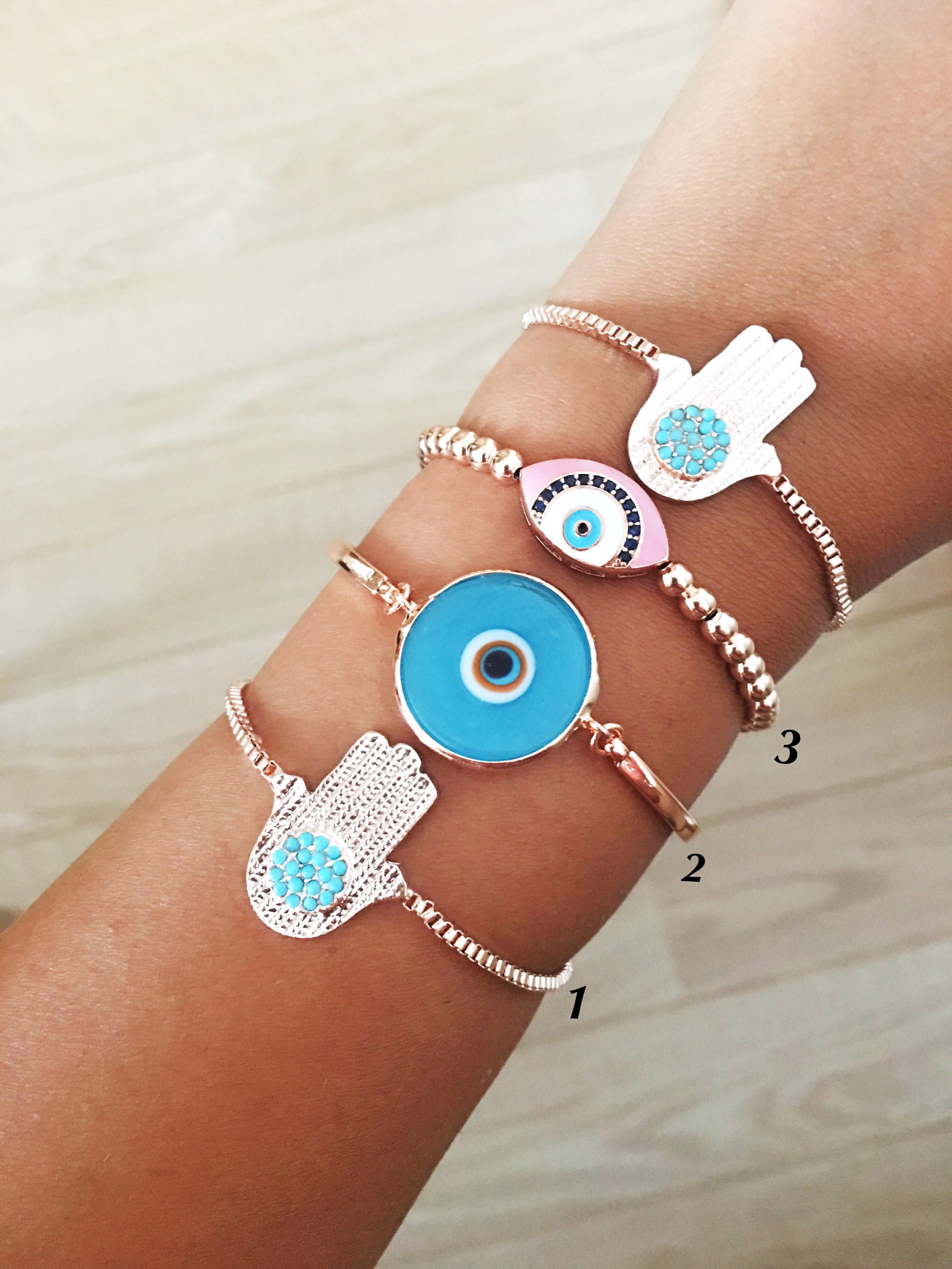 A beautiful rose gold bracelet set featuring an evil eye hamsa design, showcasing multiple bracelets with intricate details and adjustable features.