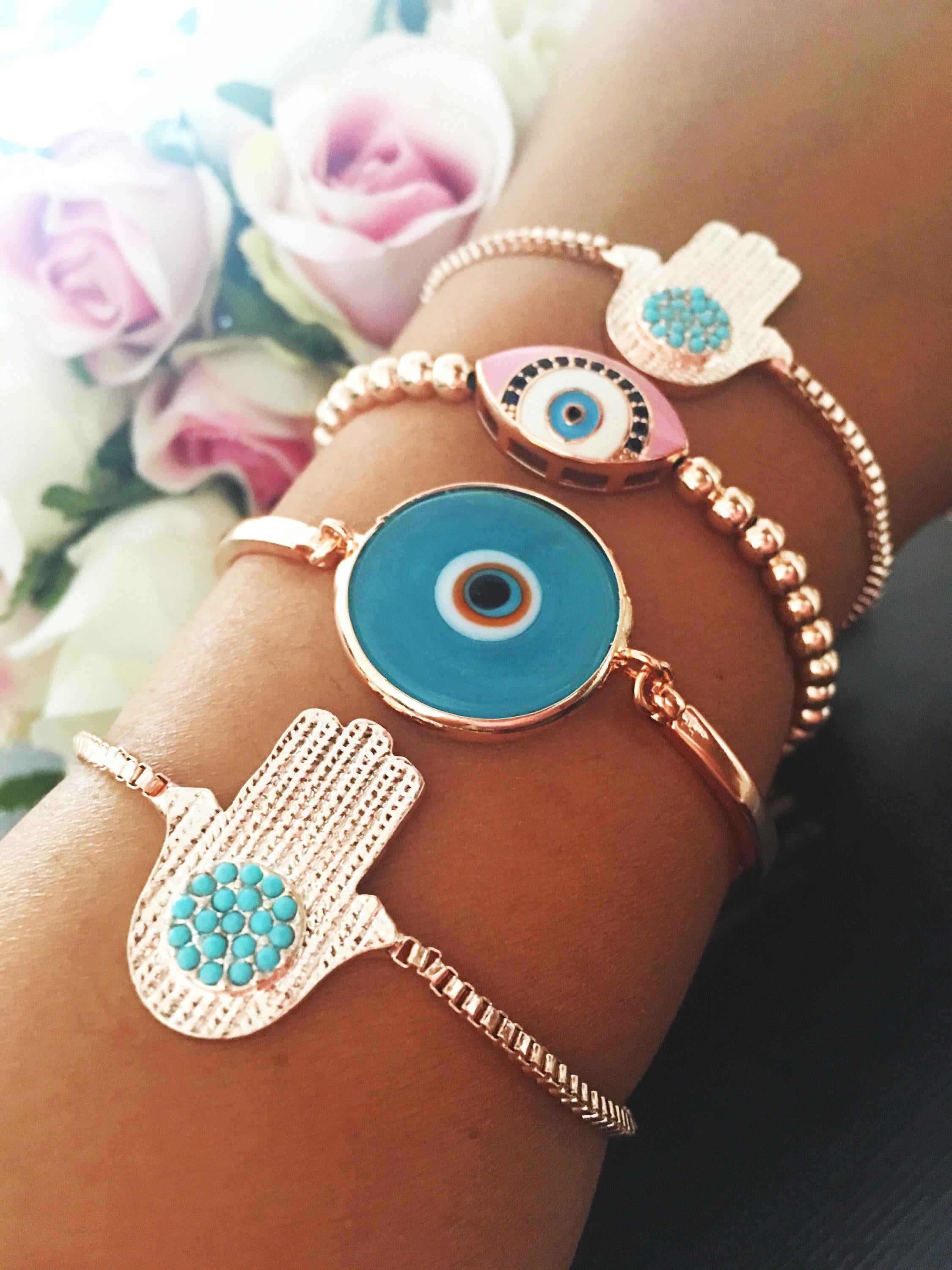 A beautiful rose gold bracelet set featuring an evil eye hamsa design, showcasing multiple bracelets with intricate details and adjustable features.