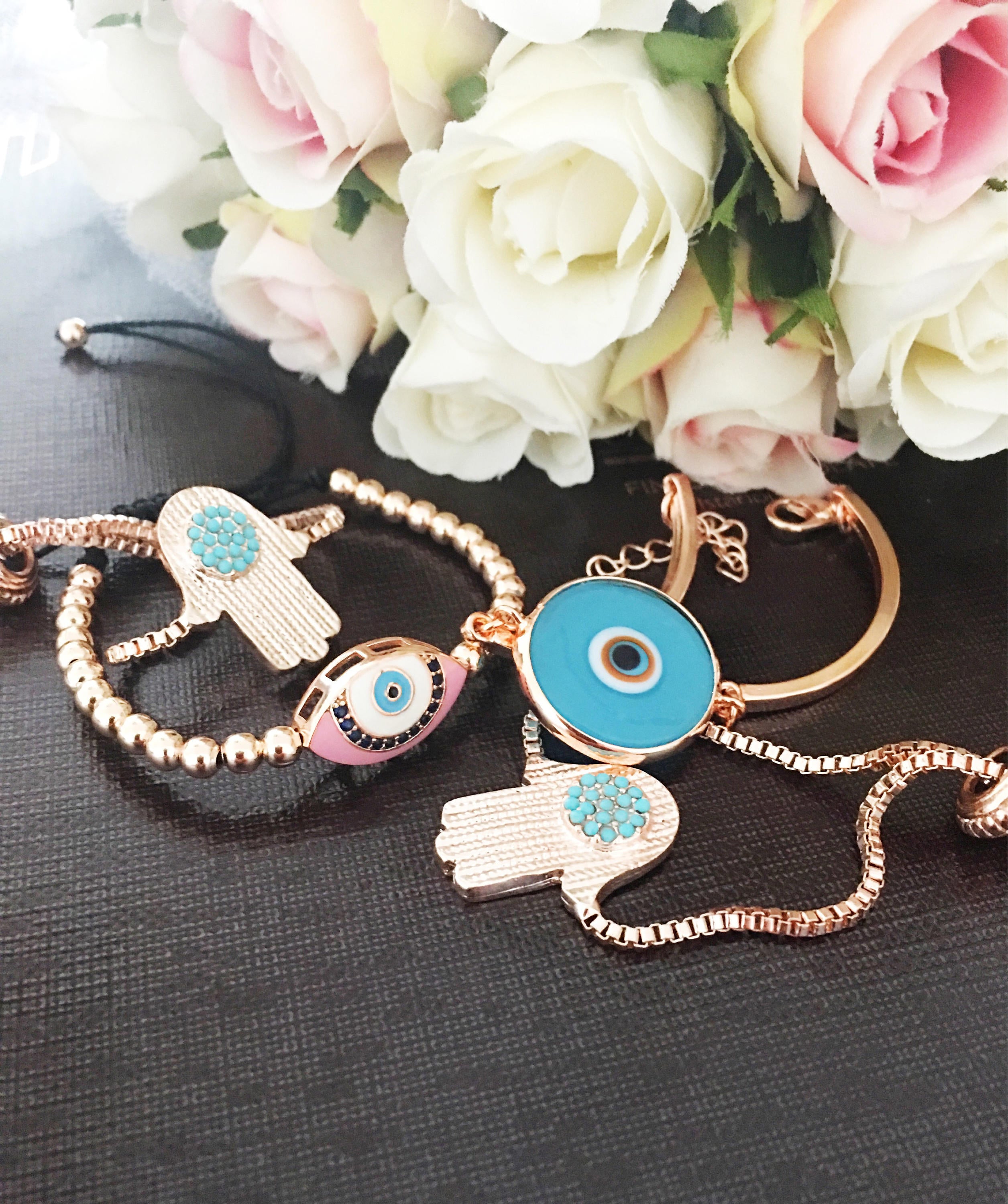 A beautiful rose gold bracelet set featuring an evil eye hamsa design, showcasing multiple bracelets with intricate details and adjustable features.