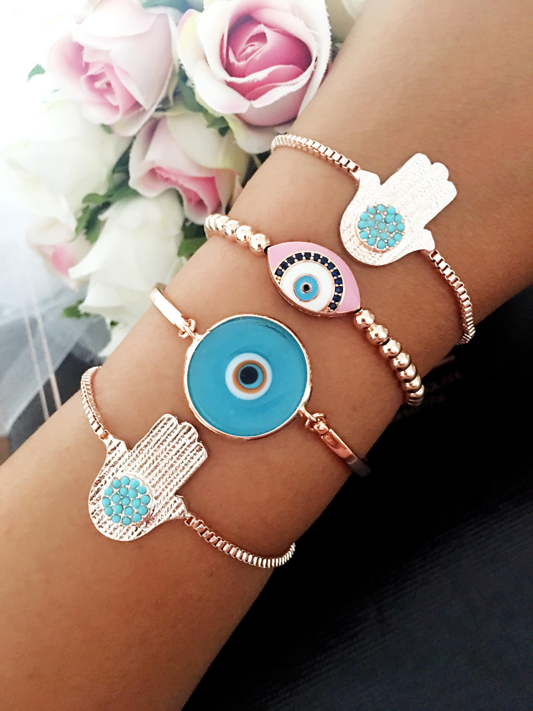 A beautiful rose gold bracelet set featuring an evil eye hamsa design, showcasing multiple bracelets with intricate details and adjustable features.