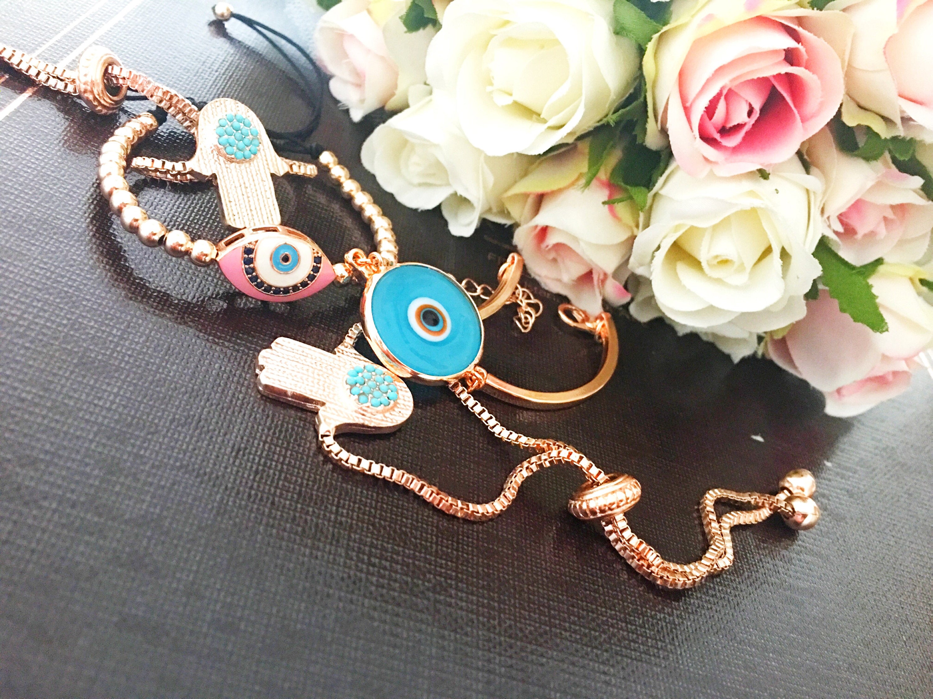 A beautiful rose gold bracelet set featuring an evil eye hamsa design, showcasing multiple bracelets with intricate details and adjustable features.