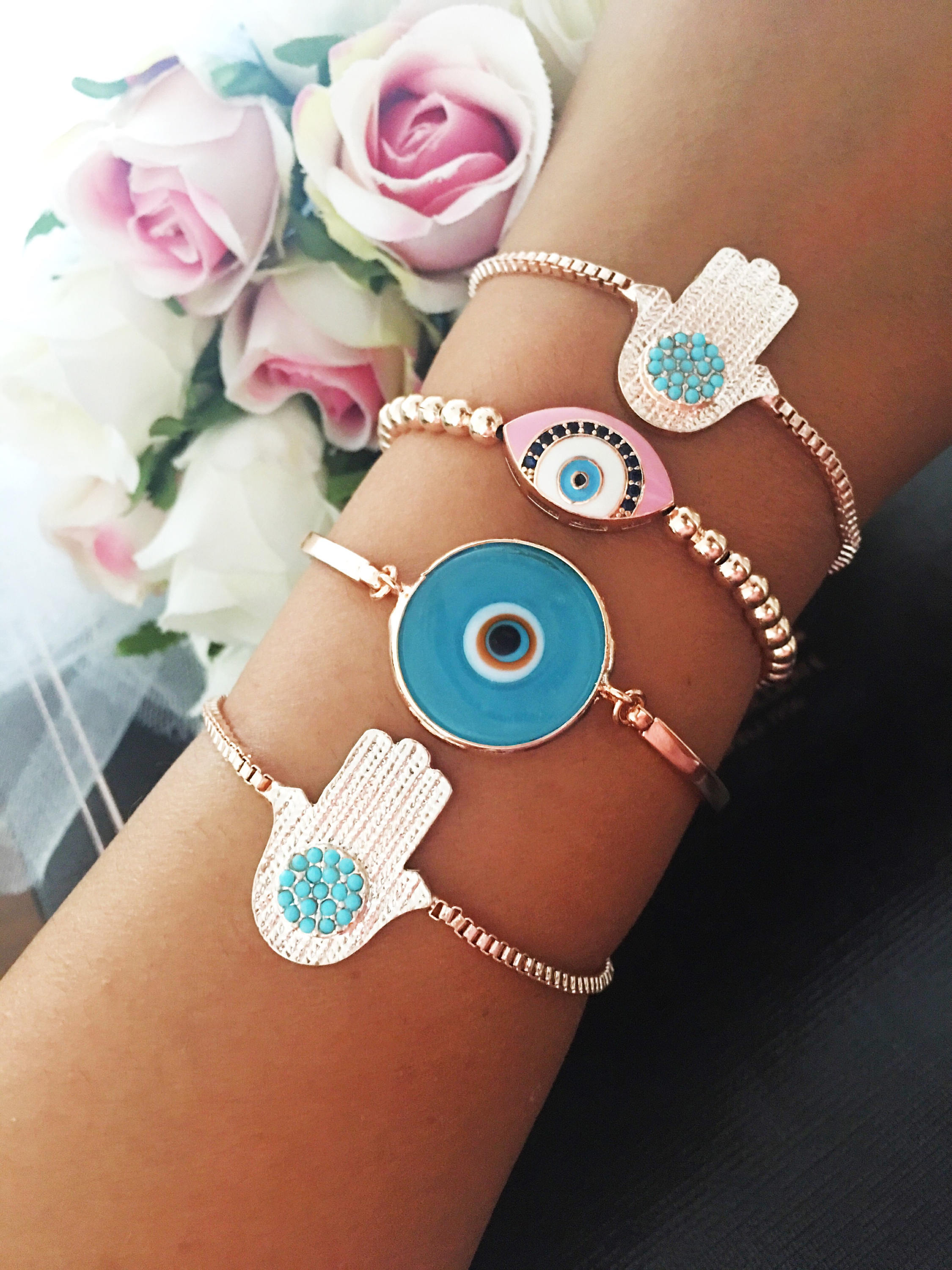 A beautiful rose gold bracelet set featuring an evil eye hamsa design, showcasing multiple bracelets with intricate details and adjustable features.