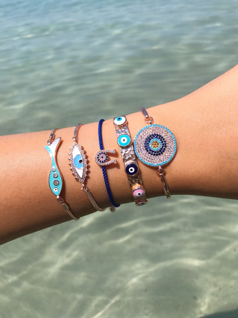 A beautiful rose gold evil eye bracelet featuring a fish and horseshoe design, made from tarnish-resistant stainless steel.