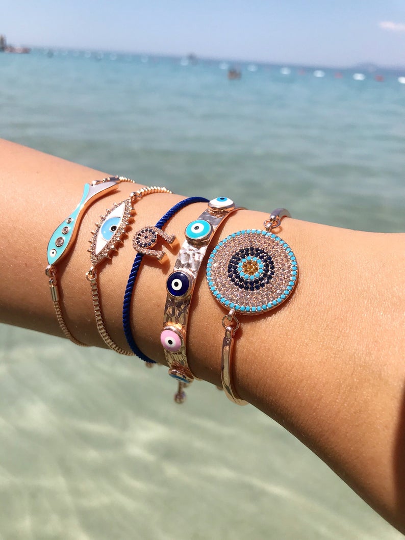 A beautiful rose gold evil eye bracelet featuring a fish and horseshoe design, made from tarnish-resistant stainless steel.