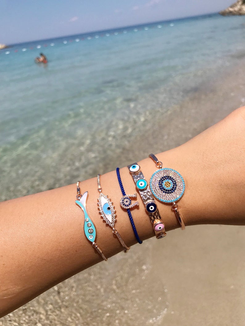 A beautiful rose gold evil eye bracelet featuring a fish and horseshoe design, made from tarnish-resistant stainless steel.