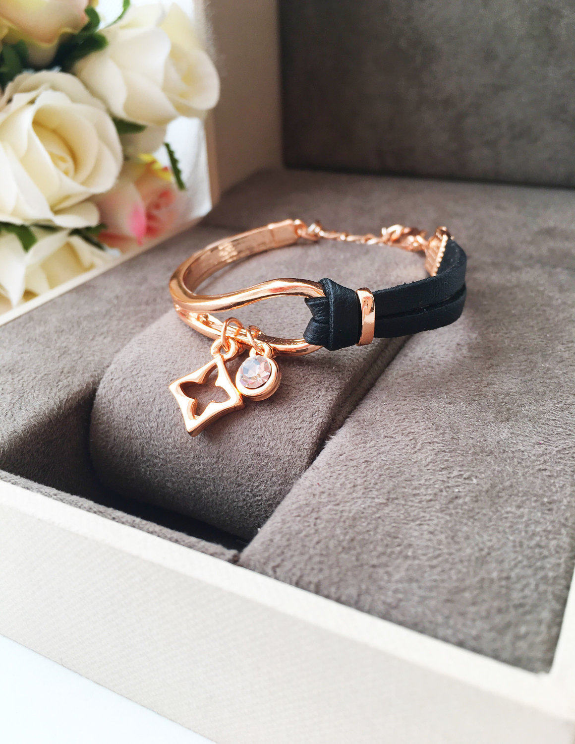 Elegant rose gold leather bracelet featuring a clover charm, adjustable design, and tarnish-resistant stainless steel material.