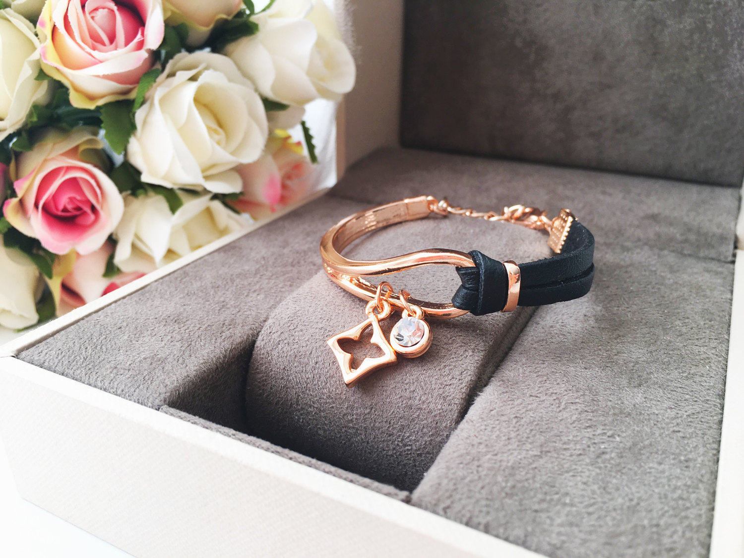 Elegant rose gold leather bracelet featuring a clover charm, adjustable design, and tarnish-resistant stainless steel material.