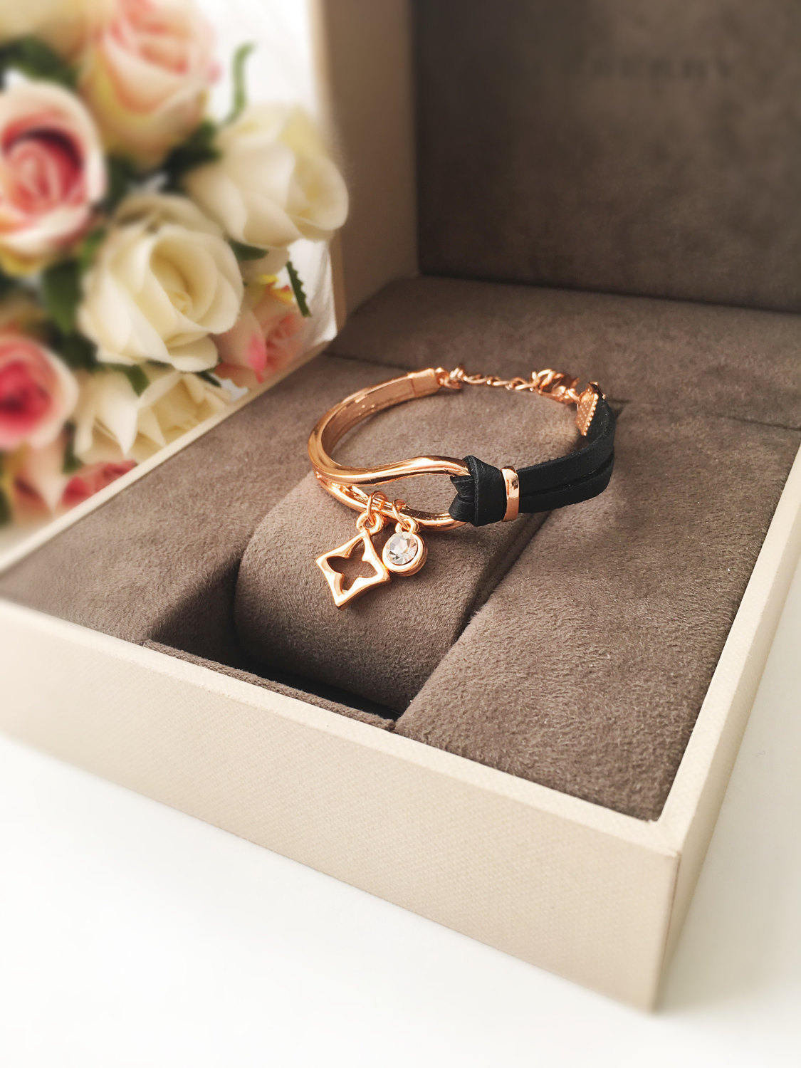 Elegant rose gold leather bracelet featuring a clover charm, adjustable design, and tarnish-resistant stainless steel material.