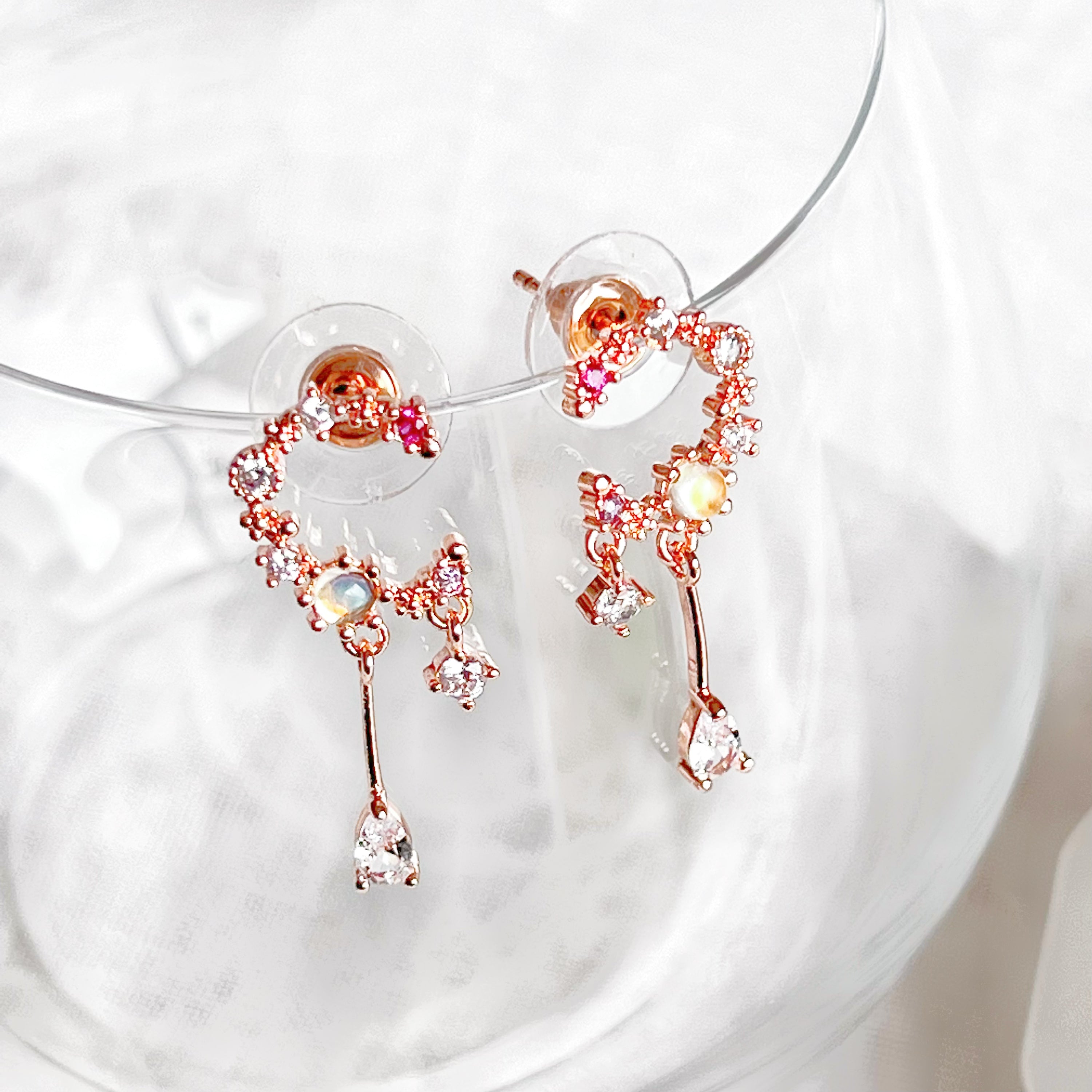 A pair of stunning Rose Gold Moon Drop Earrings featuring a unique wreath design with stars and a crescent moon, crafted from sterling silver and gold-plated bronze.