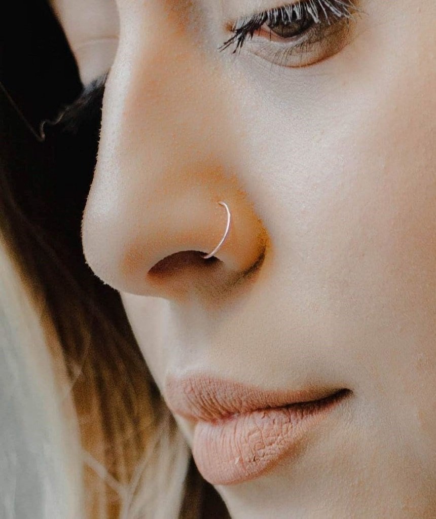 A delicate rose gold nose ring made of sterling silver, showcasing its minimalist design and elegant finish.