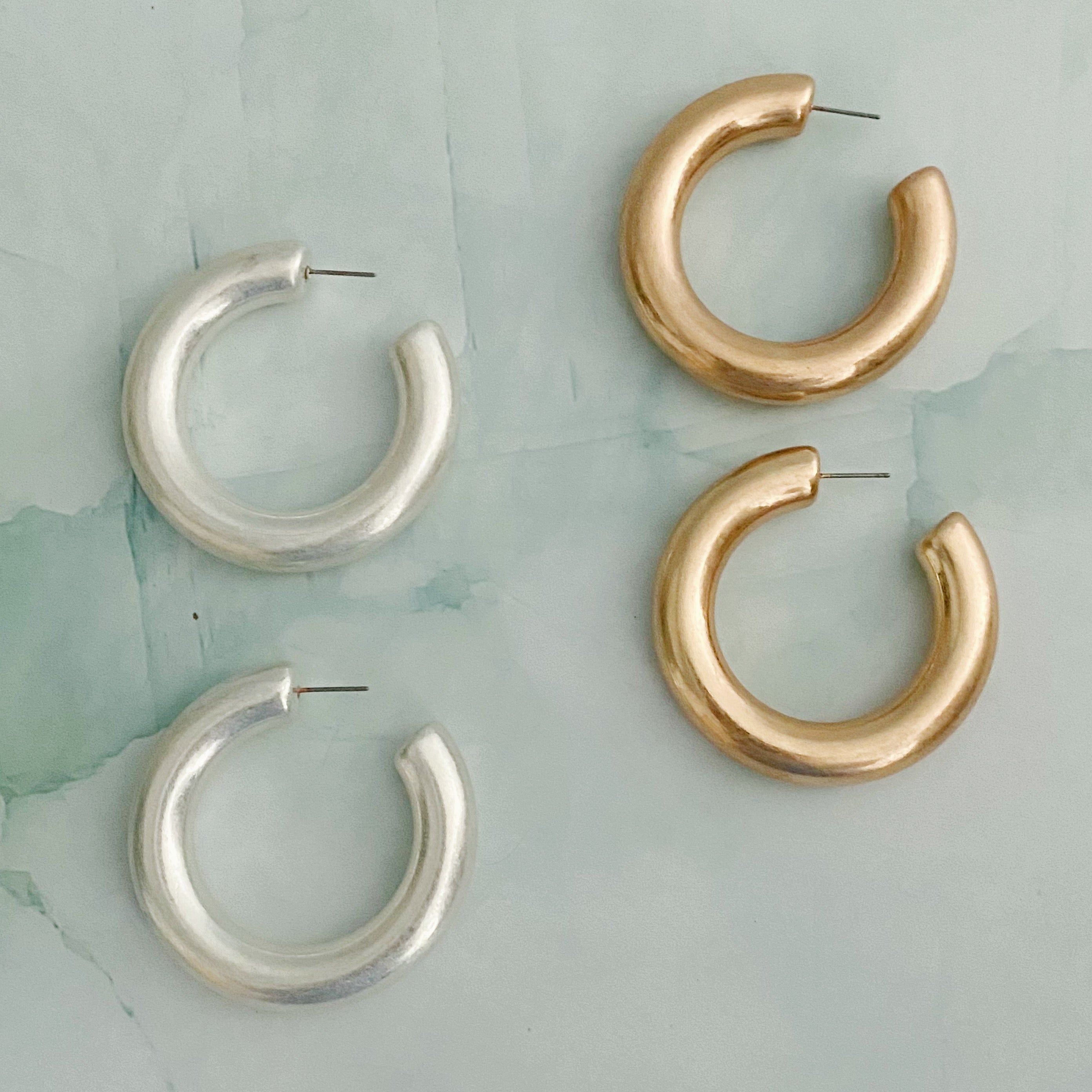 A pair of large round hoop earrings made of alloy metal, showcasing a smooth and shiny finish, perfect for modern and classic styles.