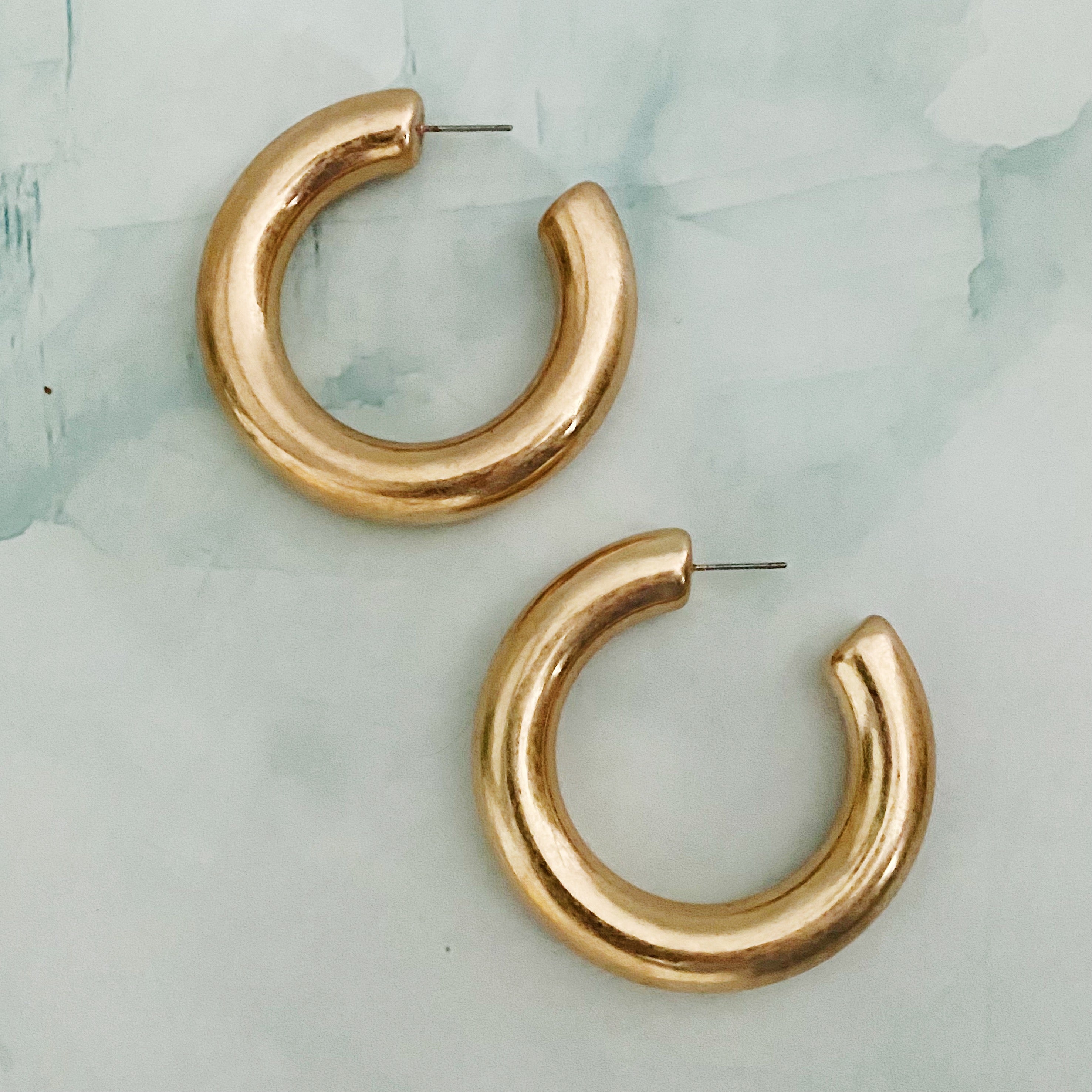 A pair of large round hoop earrings made of alloy metal, showcasing a smooth and shiny finish, perfect for modern and classic styles.