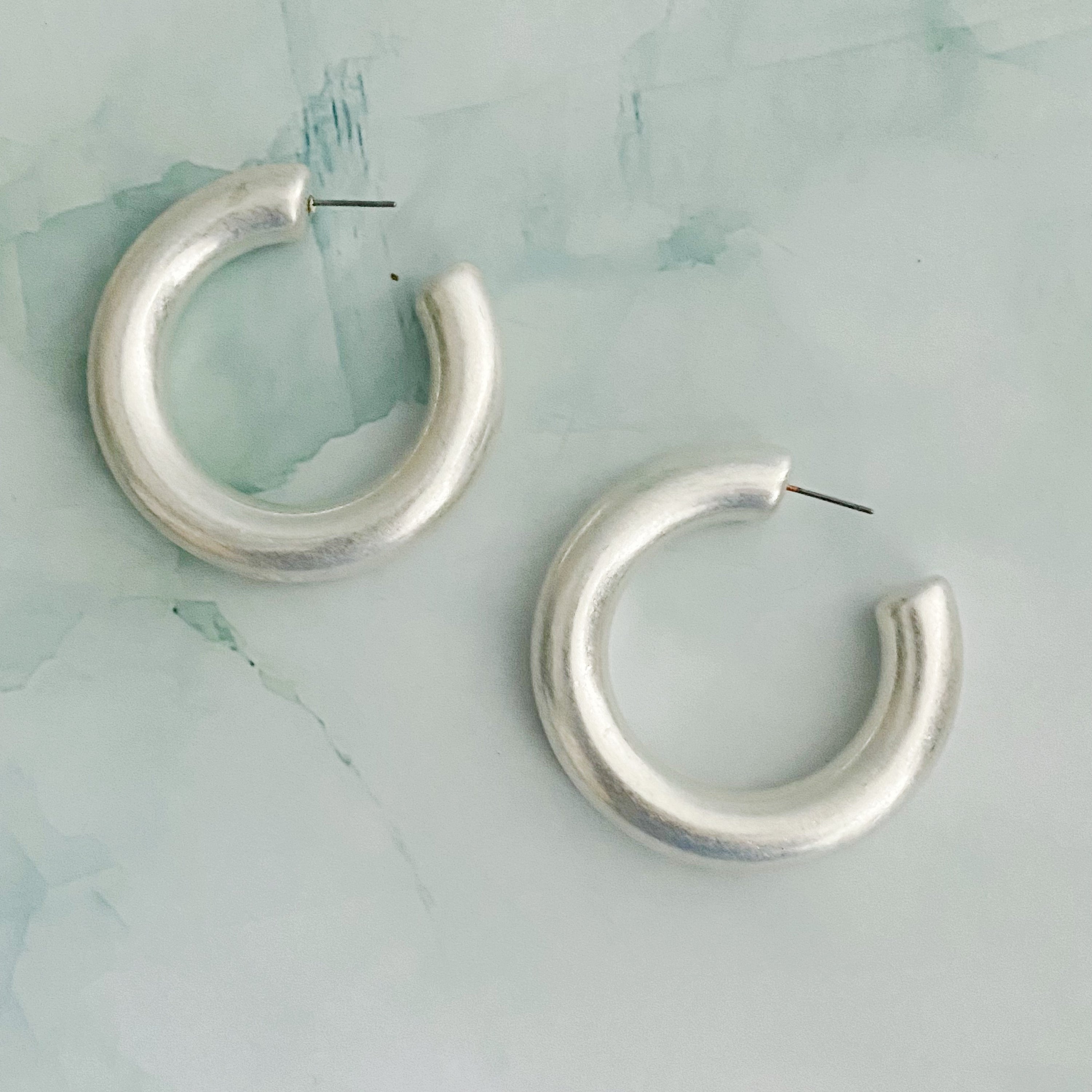 A pair of large round hoop earrings made of alloy metal, showcasing a smooth and shiny finish, perfect for modern and classic styles.