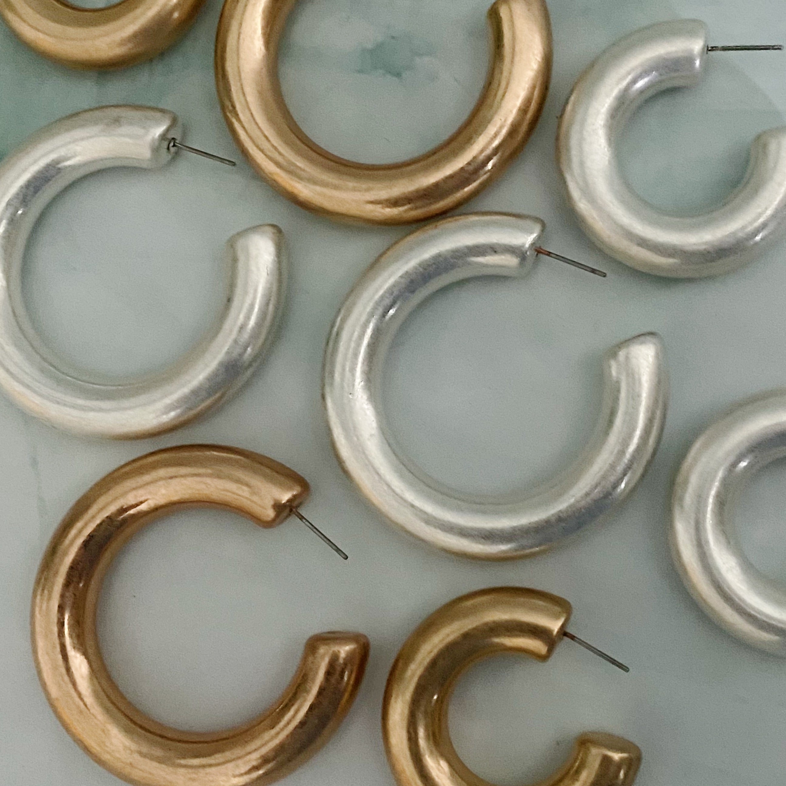 A pair of large round hoop earrings made of alloy metal, showcasing a smooth and shiny finish, perfect for modern and classic styles.