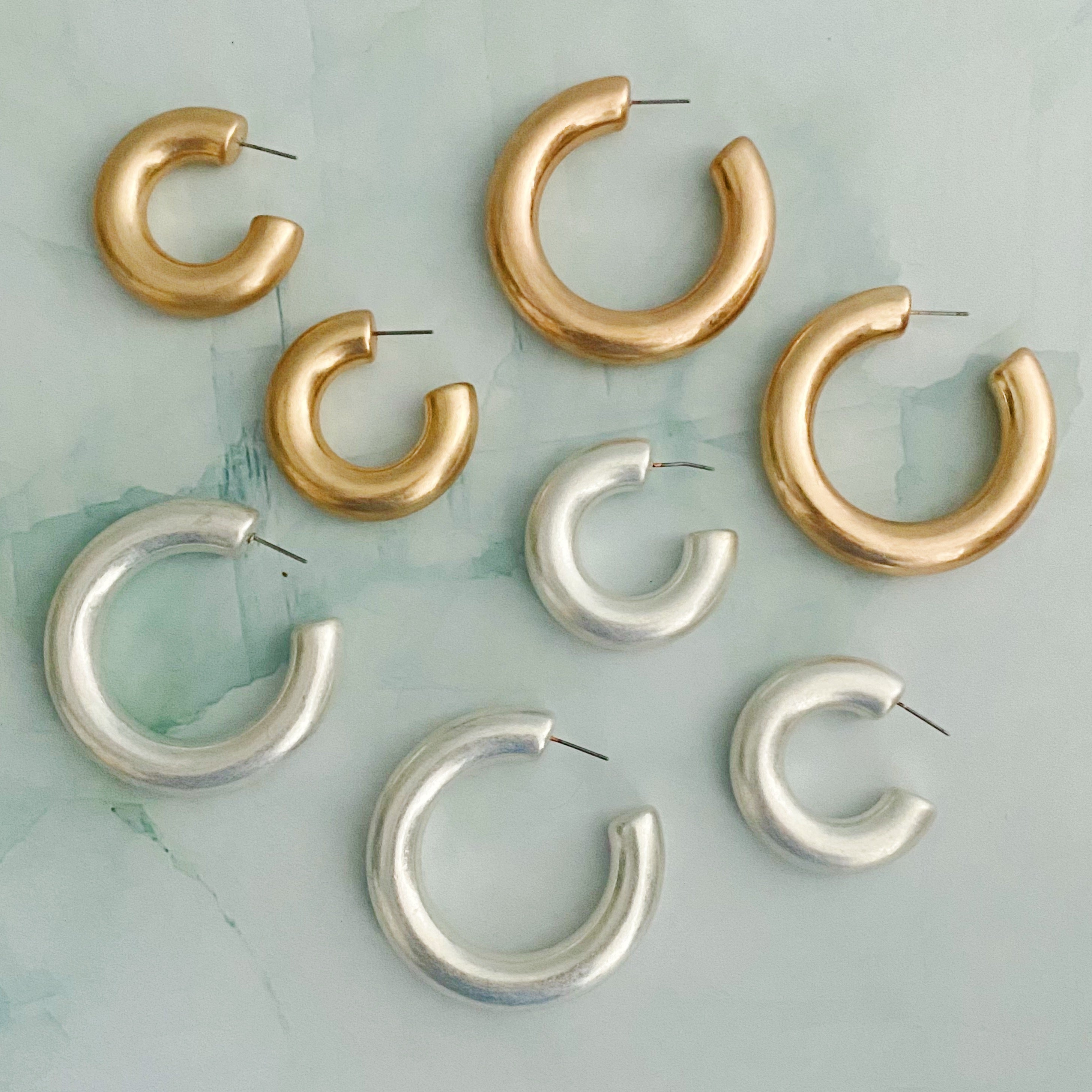 A pair of large round hoop earrings made of alloy metal, showcasing a smooth and shiny finish, perfect for modern and classic styles.