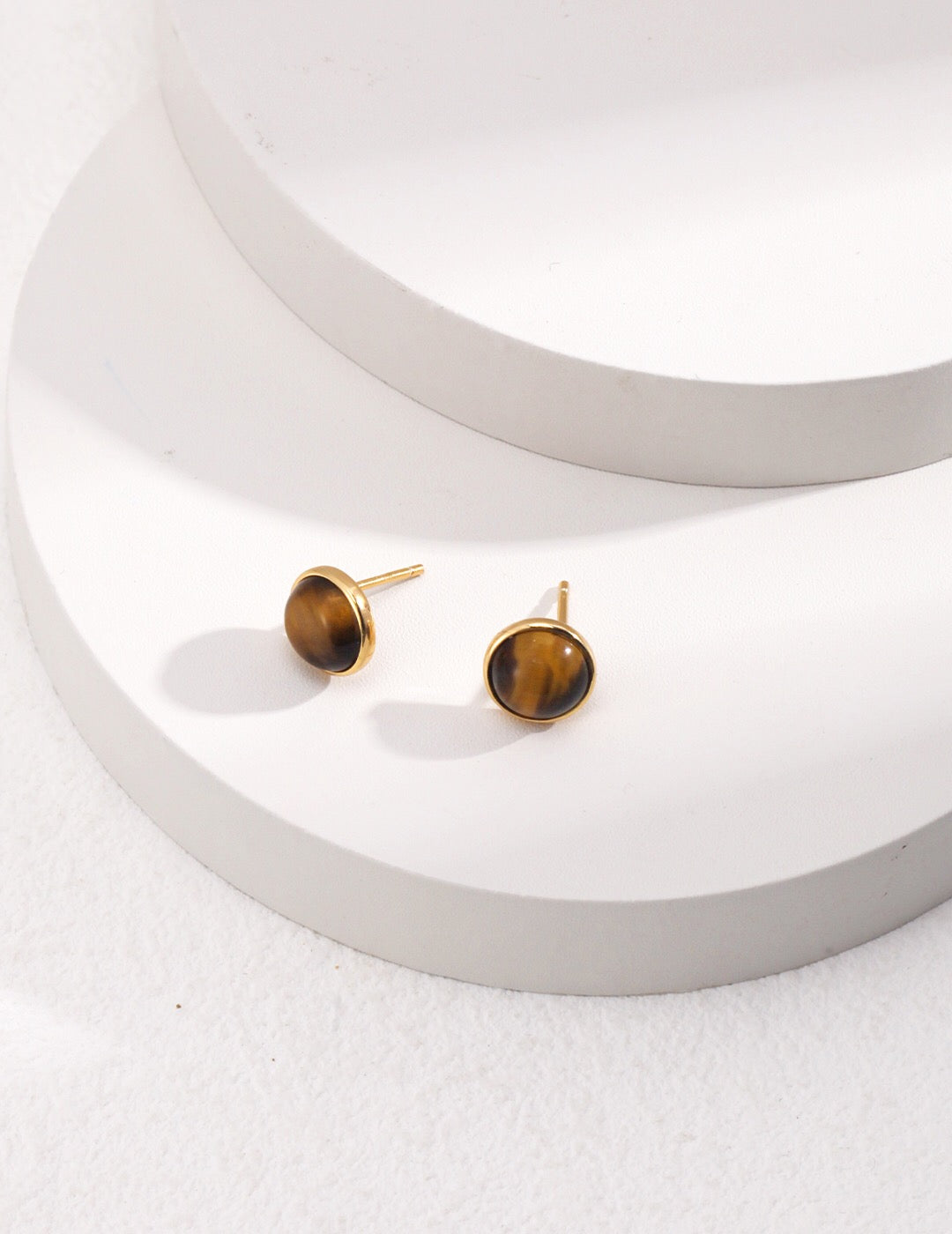 A pair of round removable earrings featuring tiger eye stones set in gold vermeil, showcasing their elegant design and craftsmanship.