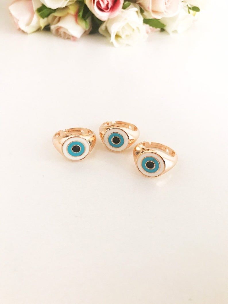 Round Turquoise Evil Eye Ring featuring a white evil eye bead and rose gold accents, adjustable design for all sizes.