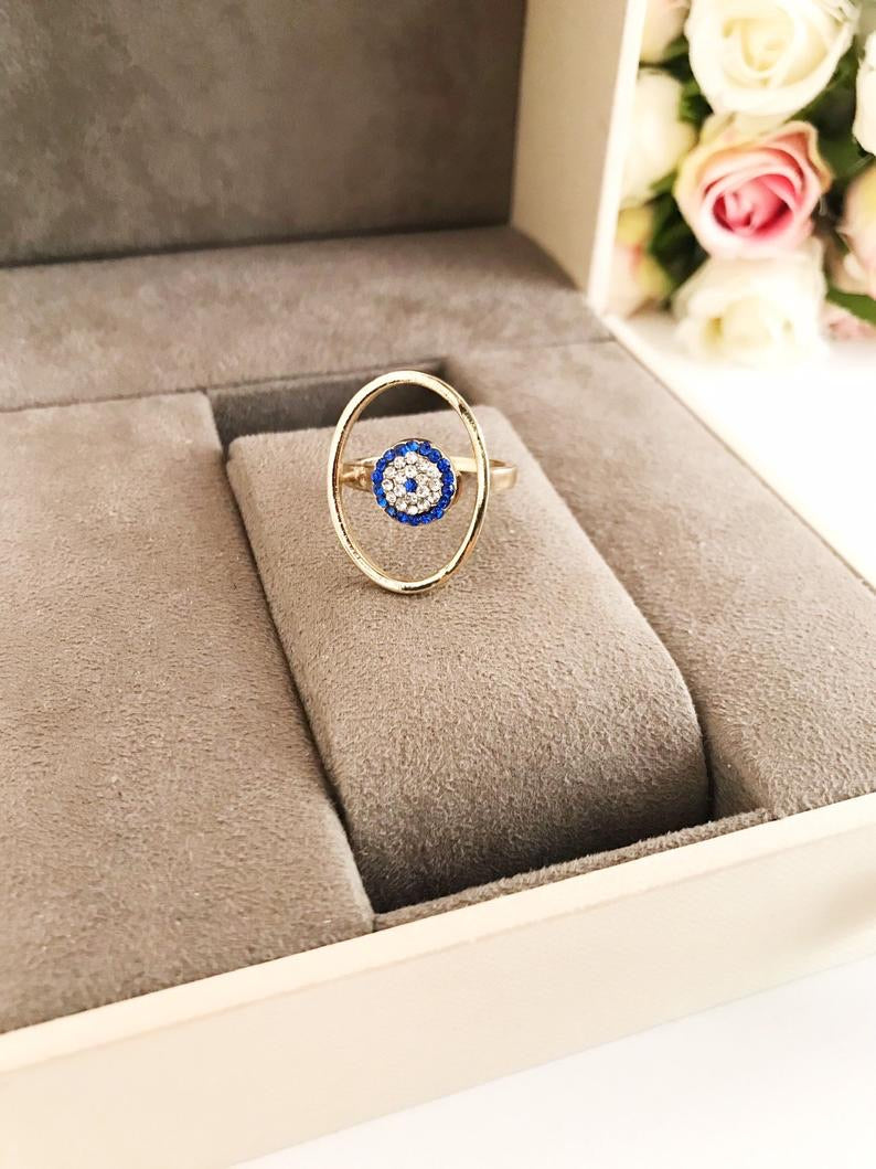 Round Zirconia Evil Eye Beads featuring a gold oval frame and blue evil eye bead, symbolizing protection and elegance.