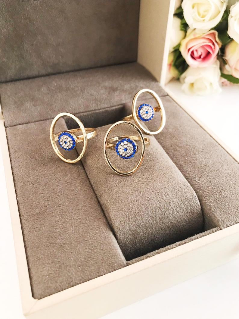 Round Zirconia Evil Eye Beads featuring a gold oval frame and blue evil eye bead, symbolizing protection and elegance.