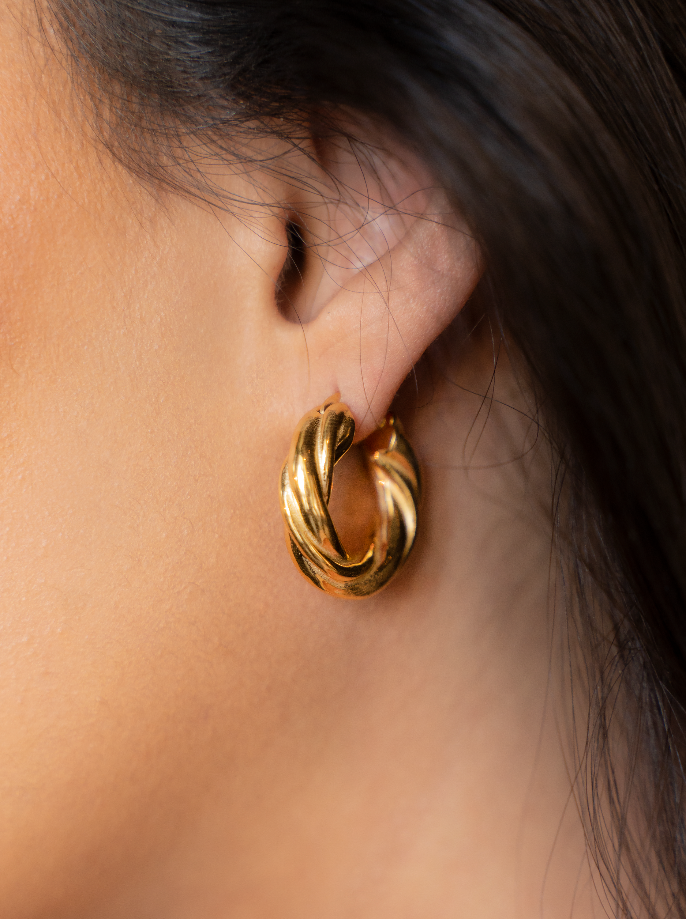 Stylish ROXY Hoops featuring a twisted tubular design in shiny 18k gold plated stainless steel, perfect for any occasion.