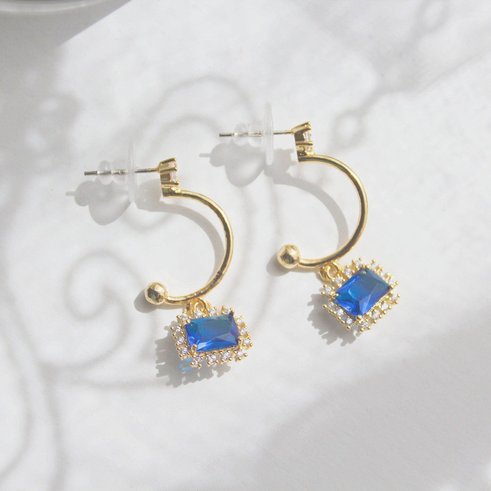 Elegant royal blue square crystal half hoop earrings made with sterling silver and gold plated bronze.