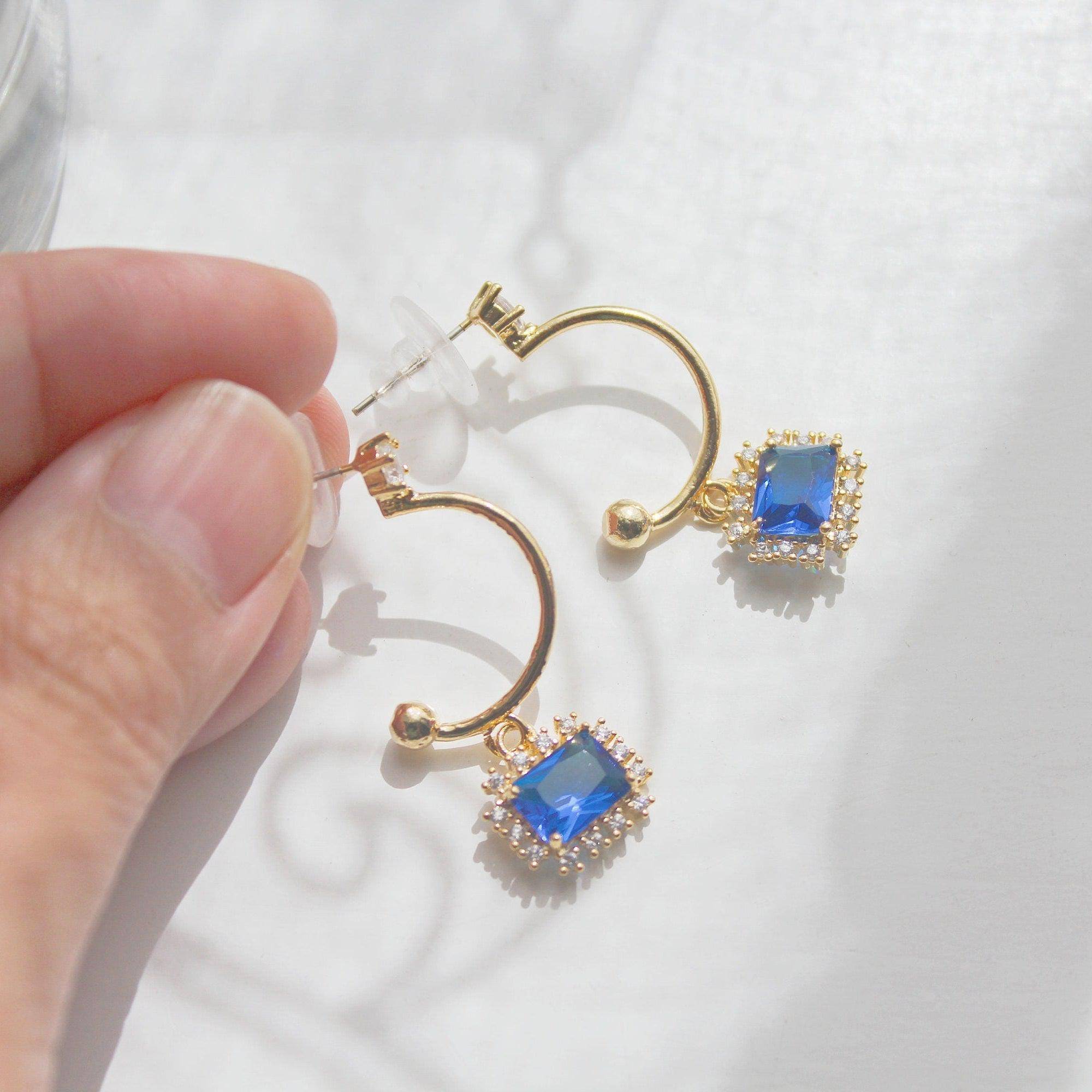 Elegant royal blue square crystal half hoop earrings made with sterling silver and gold plated bronze.