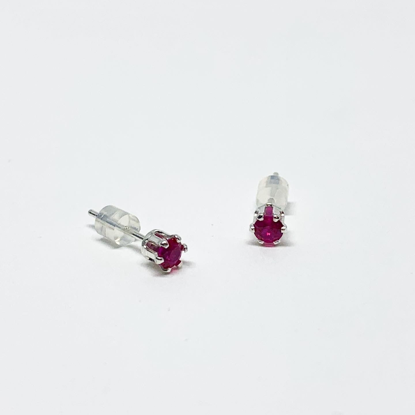 A pair of stunning ruby birthstone earrings featuring 3mm round faceted rubies set in 6 prong stud design, available in sterling silver or yellow gold fill.