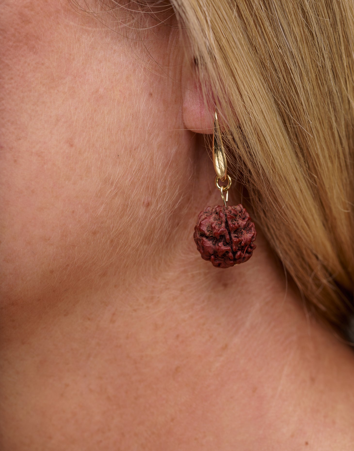 A pair of Rudraksha earrings featuring natural Rudraksha seeds and raw brass hooks, showcasing their unique texture and organic design.