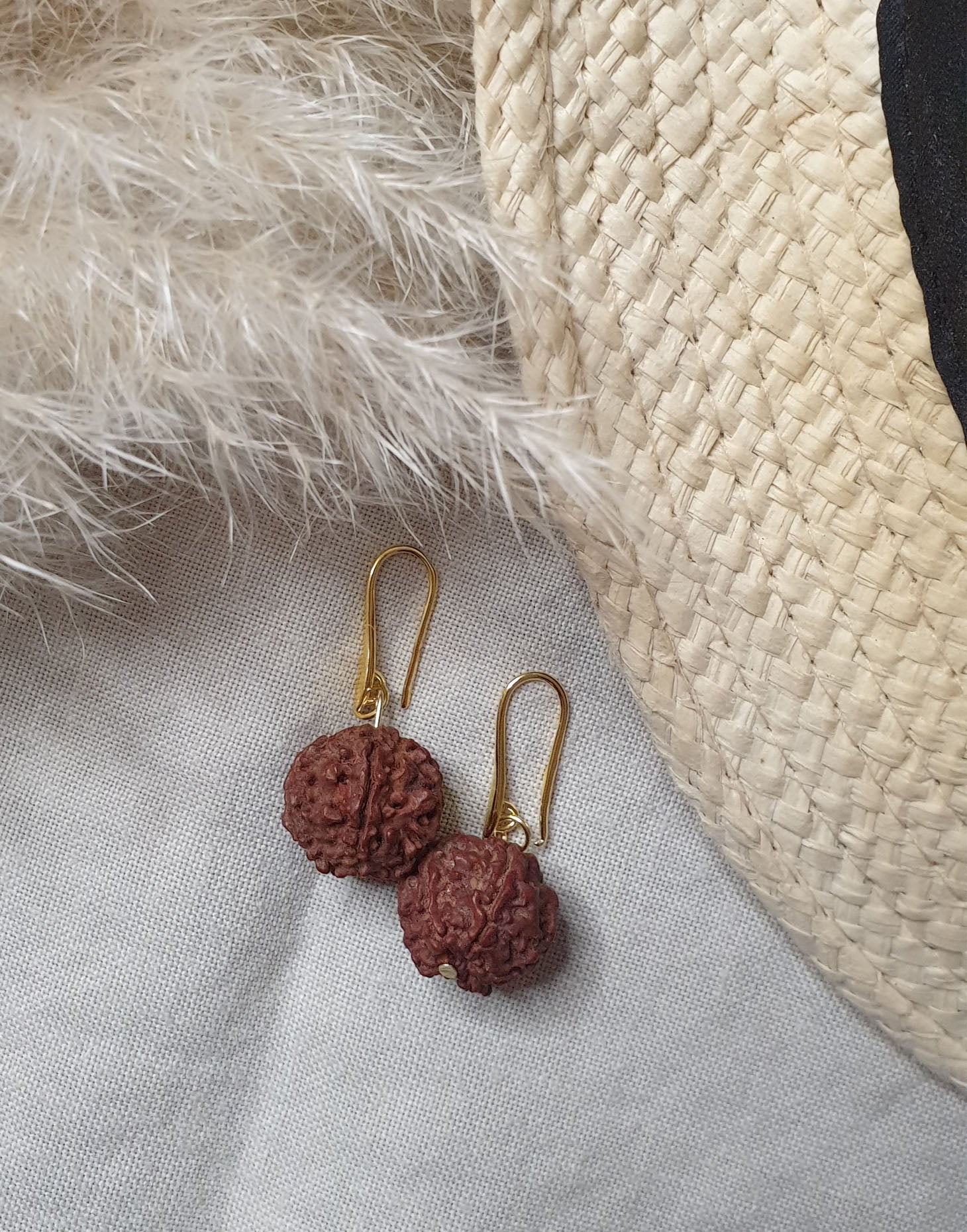 A pair of Rudraksha earrings featuring natural Rudraksha seeds and raw brass hooks, showcasing their unique texture and organic design.