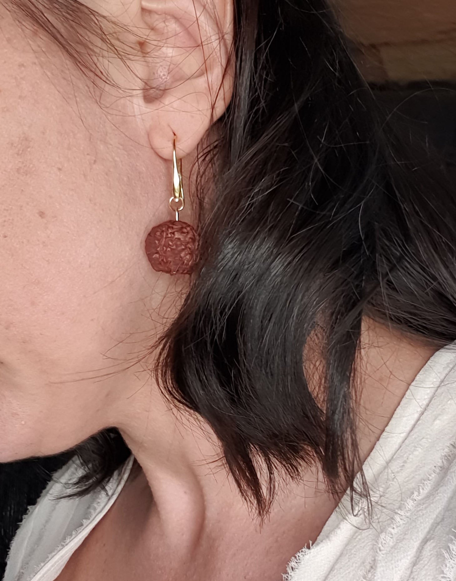 A pair of Rudraksha earrings featuring natural Rudraksha seeds and raw brass hooks, showcasing their unique texture and organic design.