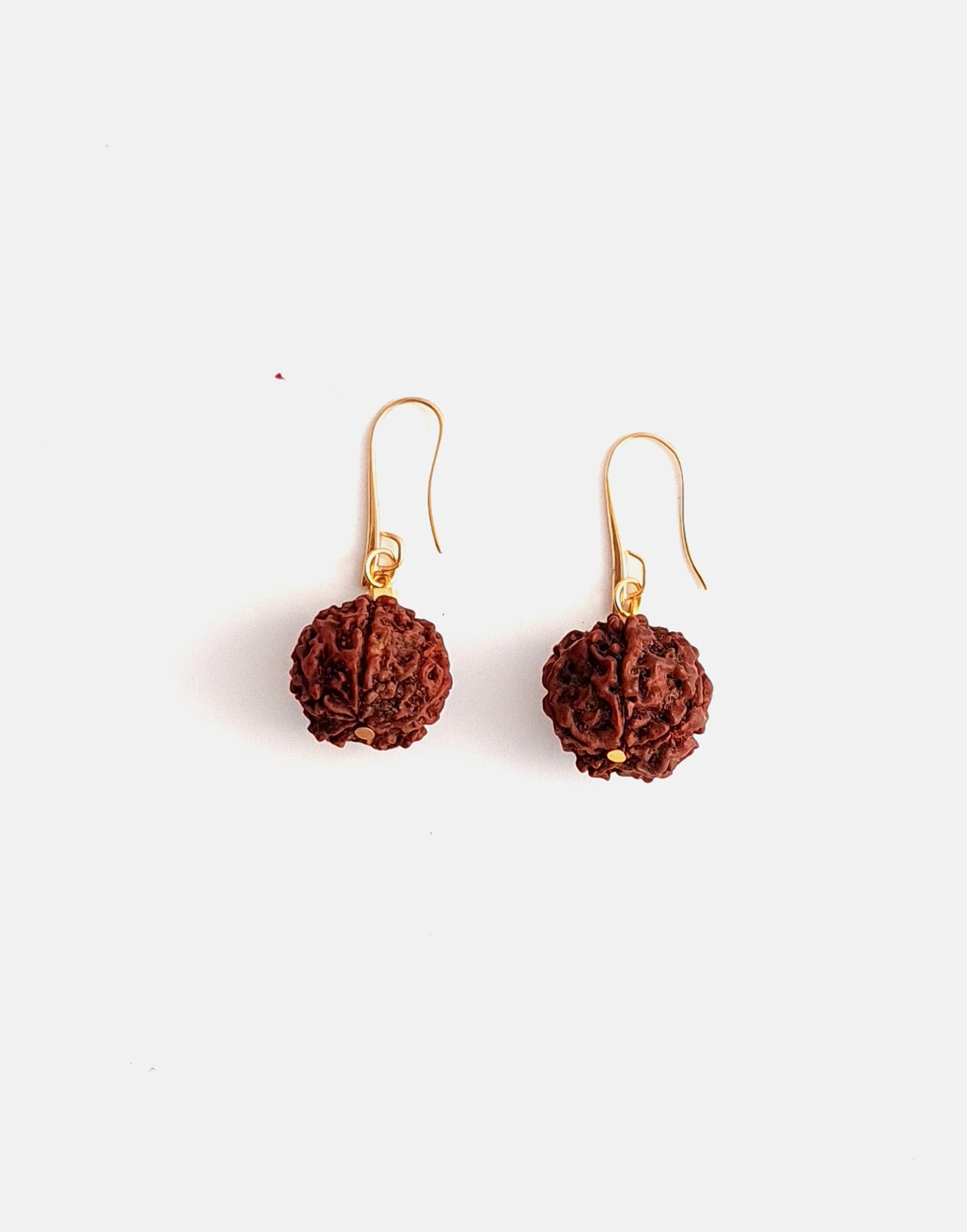 A pair of Rudraksha earrings featuring natural Rudraksha seeds and raw brass hooks, showcasing their unique texture and organic design.