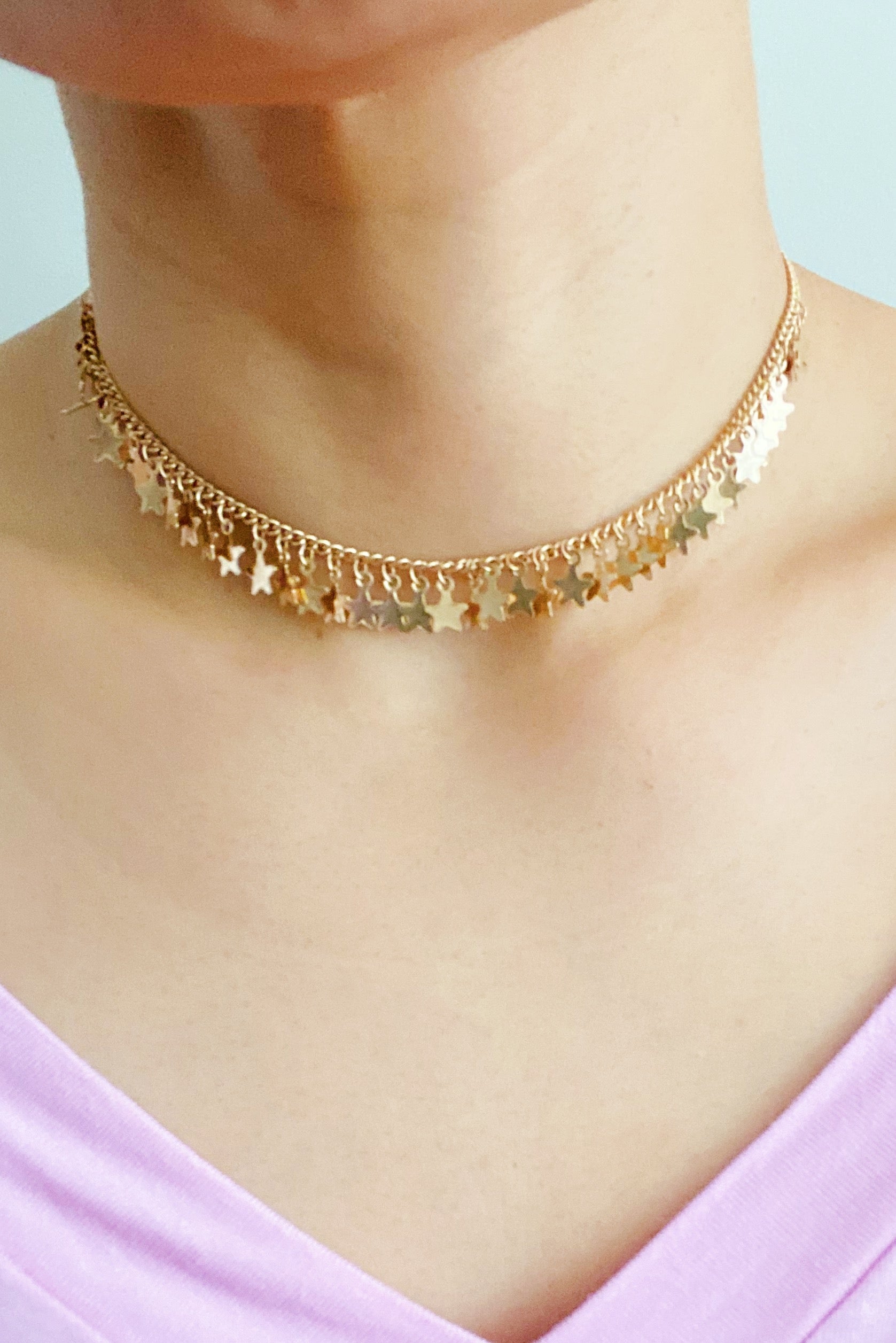 A beautiful choker necklace featuring multiple small star charms on a delicate chain, perfect for adding a celestial touch to any outfit.