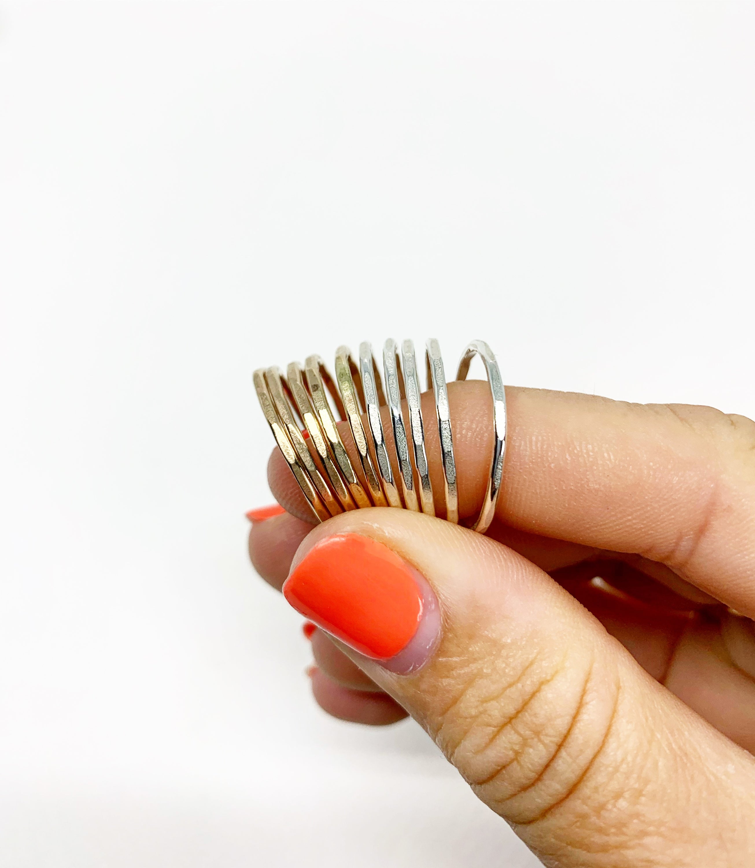 A set of Rustic Stacking Rings featuring a textured hammered finish, made from recycled metals in gold, rose gold, and silver.