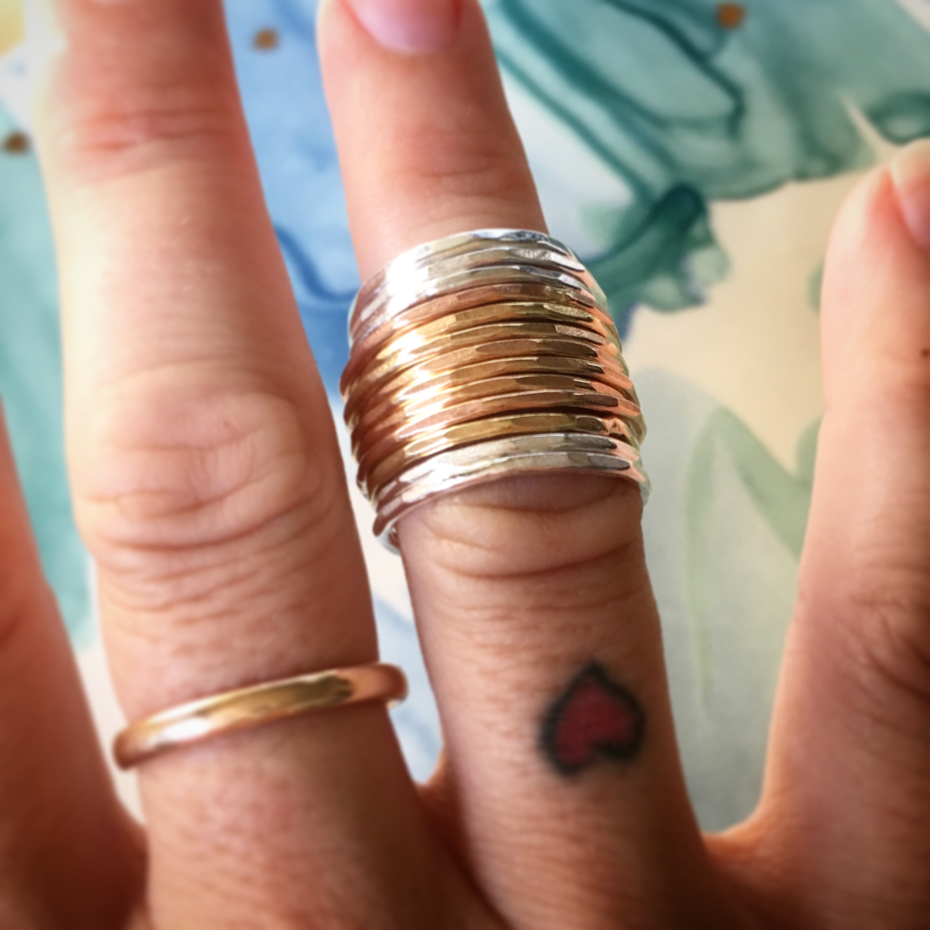 A set of Rustic Stacking Rings featuring a textured hammered finish, made from recycled metals in gold, rose gold, and silver.